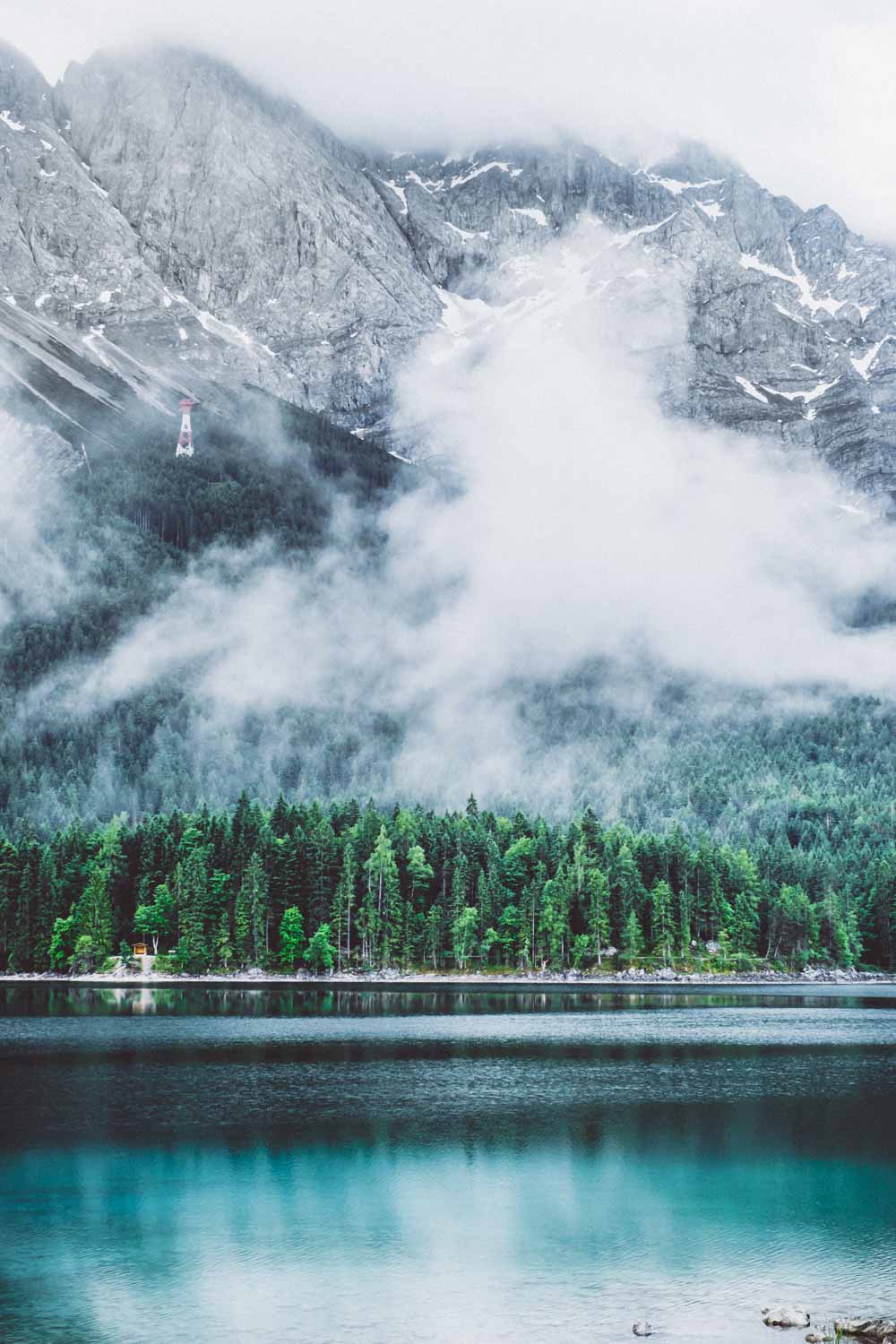 Wolken schieben sich langsam über den See und die Hänge entlang