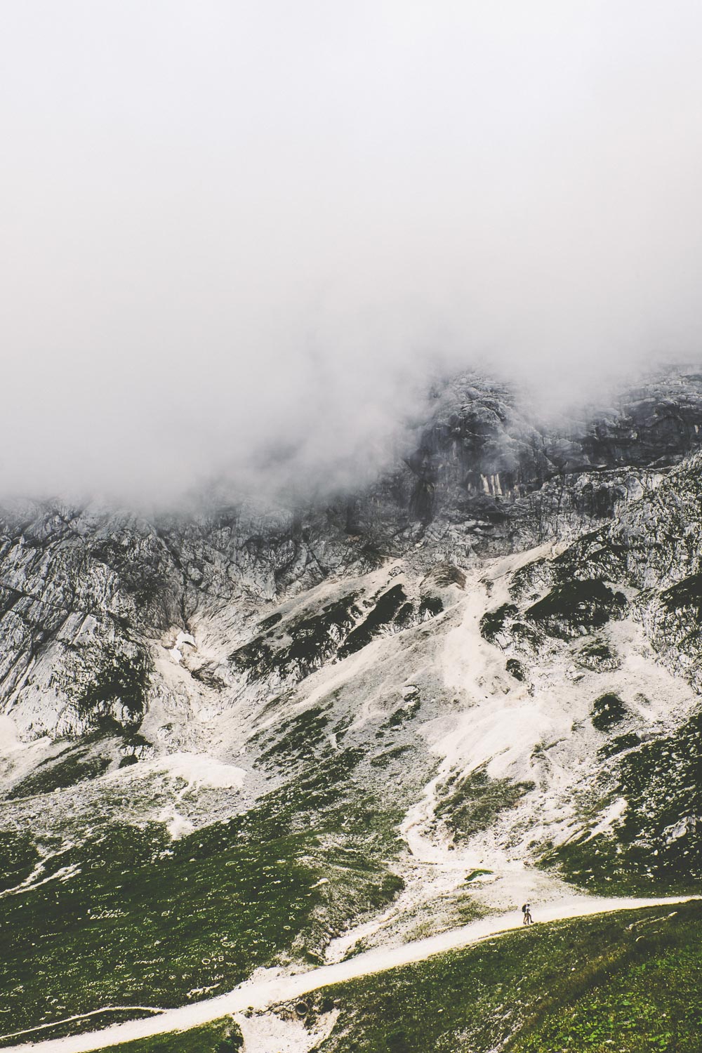Die Bergflanken verschwinden in den Wolken. Der Weg führt steil bergauf.