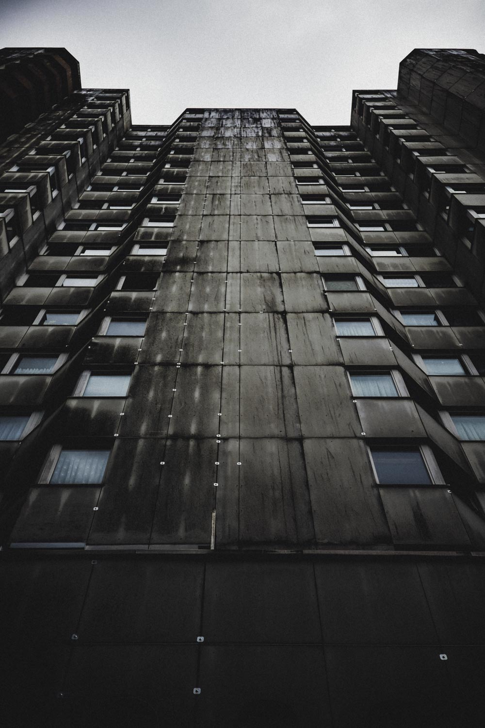 Graue Symmetrie unterbrochen von einem geöffneten Fenster