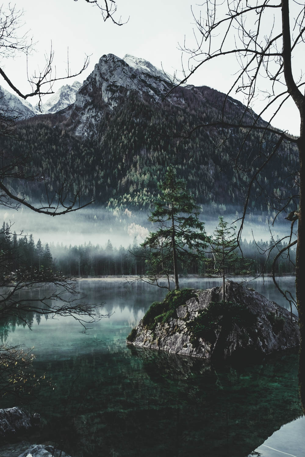 Blick durch die bereits laublosen Bäume auf die Felsen im Hintersee