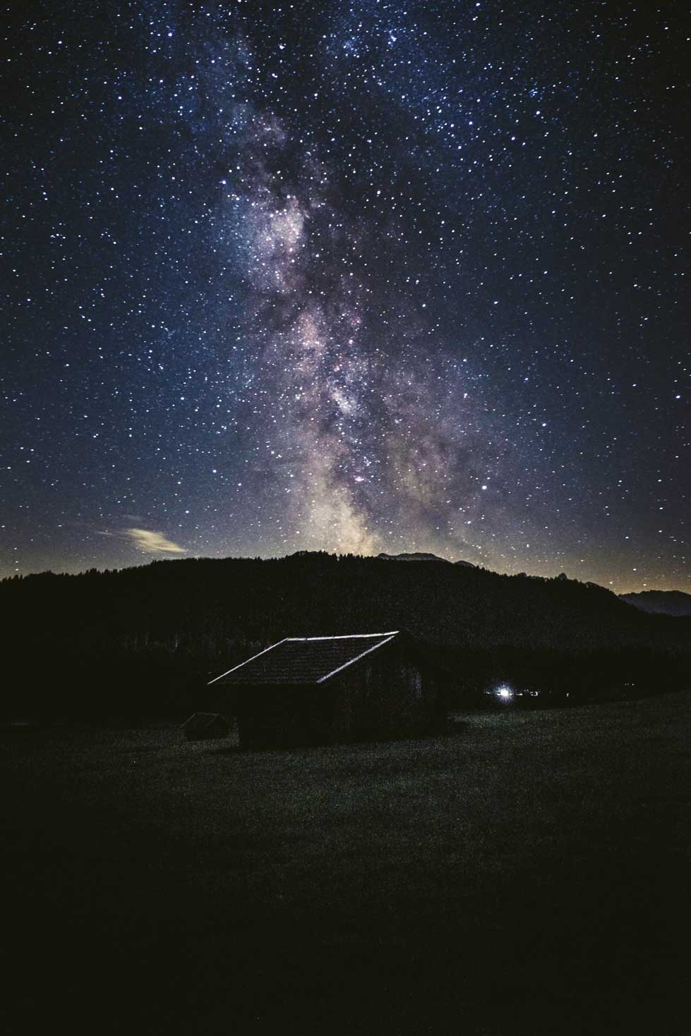 Die Milchstraße erhebt sich über einer der vielen Heuhütten am Geroldsee.