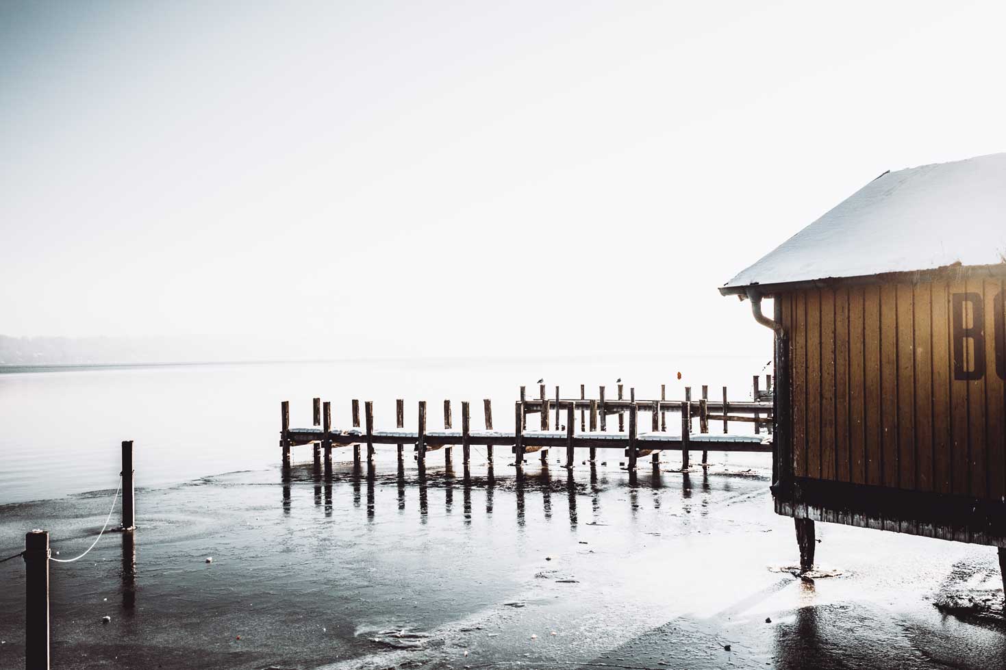 Ein Bootshaus am gefrorenen Ufer des Starnberger Sees.