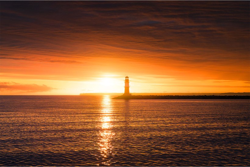 sonnenaufgang zwischen wolken und meer an der ostsee
