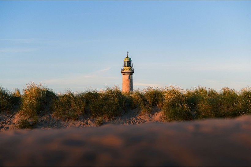 blick durch die dünen zum leuchtturm von warnemünde