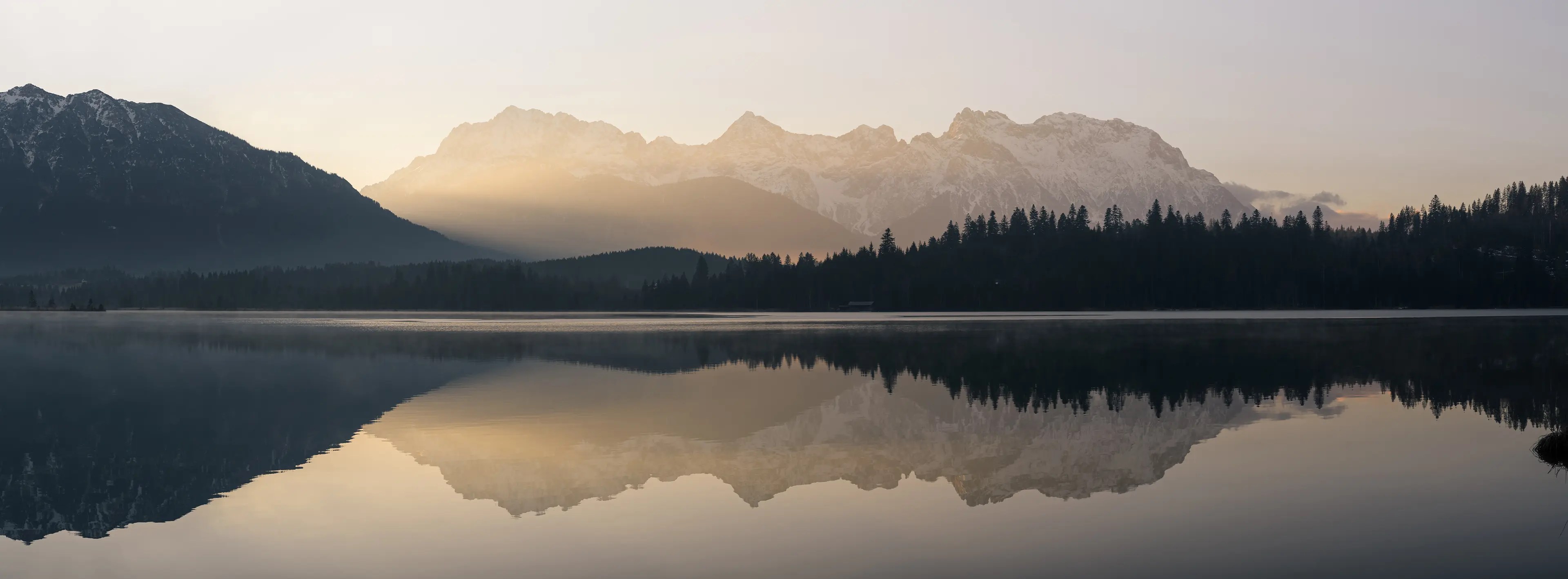 Das Karwendelgebirge leuchtet im sanften Streiflicht der aufgehenden Sonne.