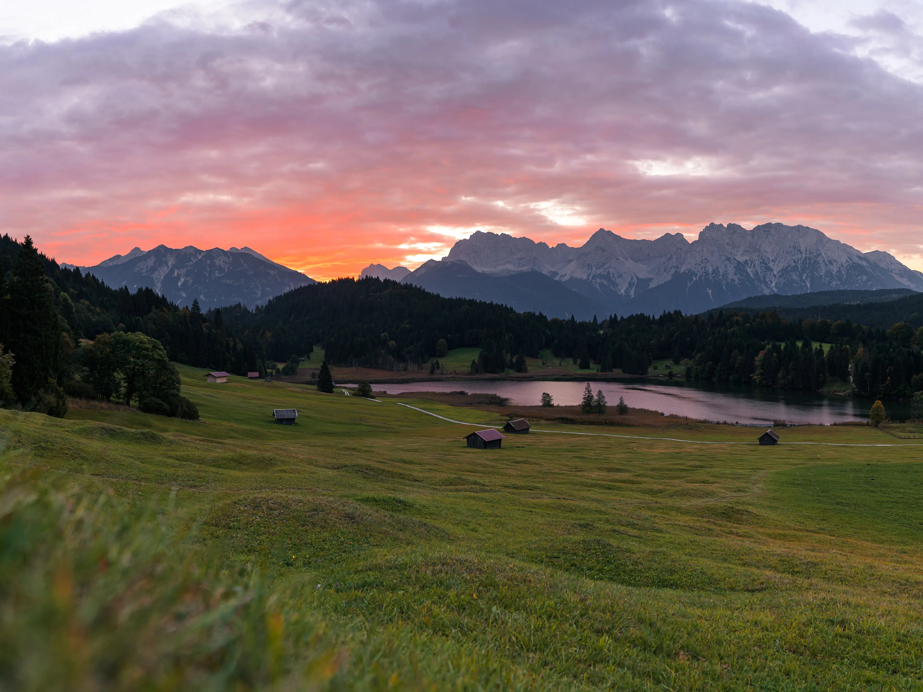 Die Sonne geht im Herbst zwischen dem Karwendelgebirge und der Soierngruppe auf. Bei einer hohen Wolkendecke ergeben sich bereits vor Sonnenaufgang tolle Farben.