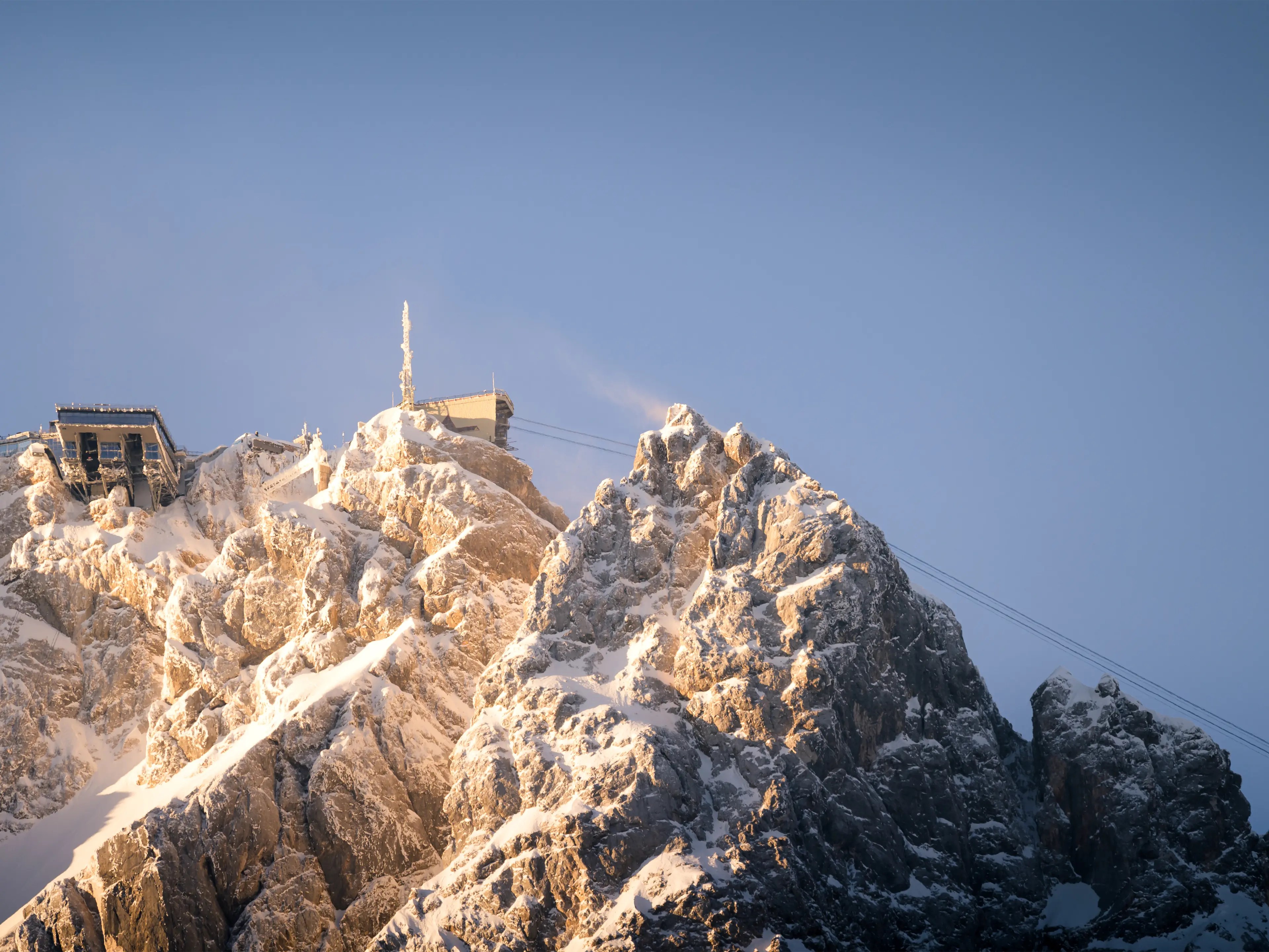 Die Zugspitze im warmem Morgenlicht und mit Eis bedeckt.