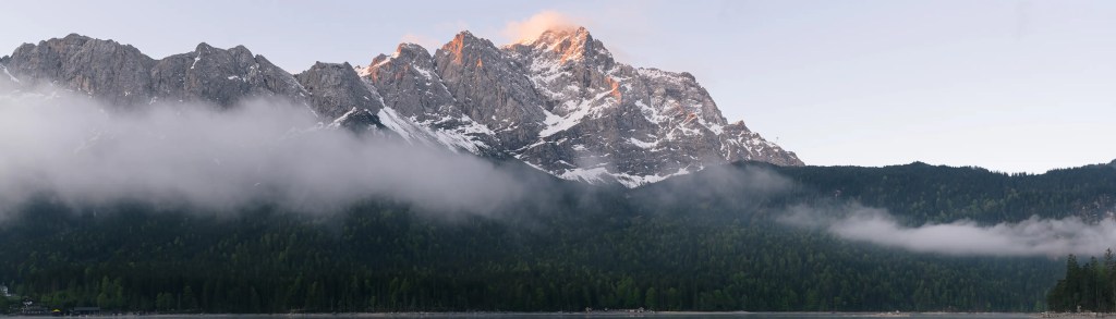 Panoramabild der Zugspitze im Morgenlicht mit leichtem Nebel im Tal