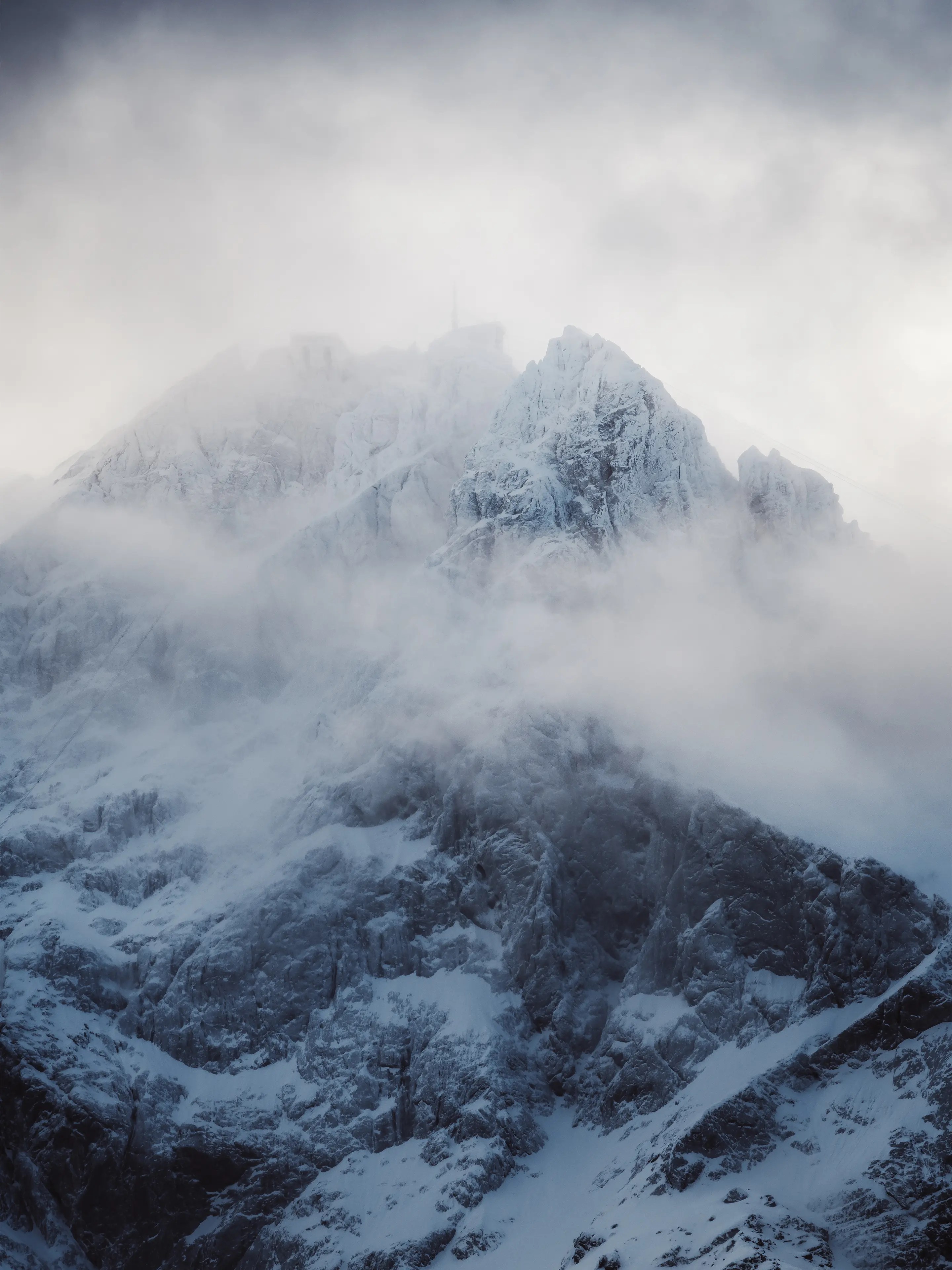 Wolken ziehen über den verschneiten Gipfel der Zugspitze