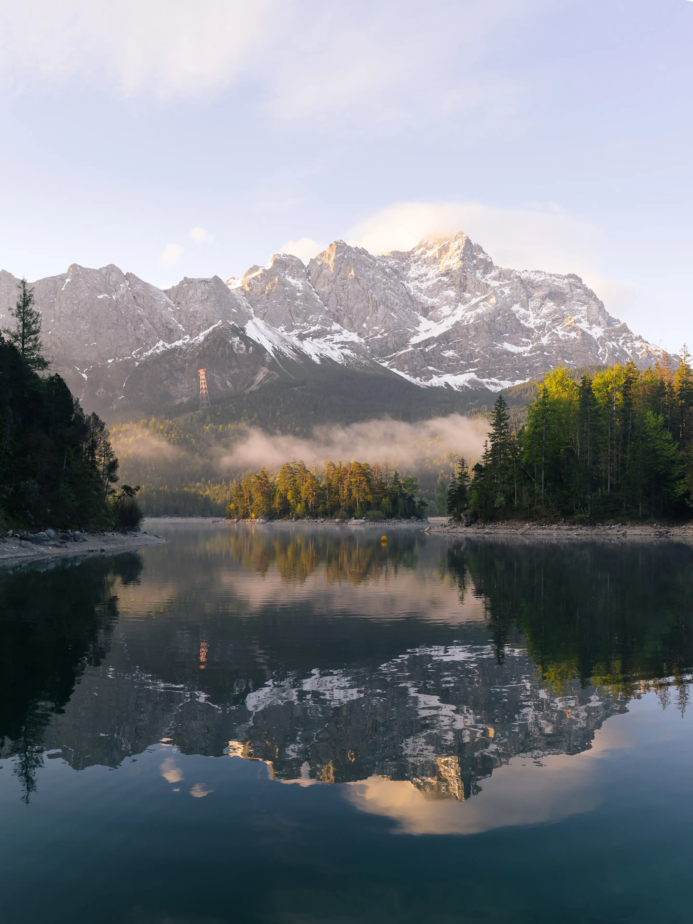 Die Zugspitze spiegelt auf dem Eibsee im Morgenlicht.