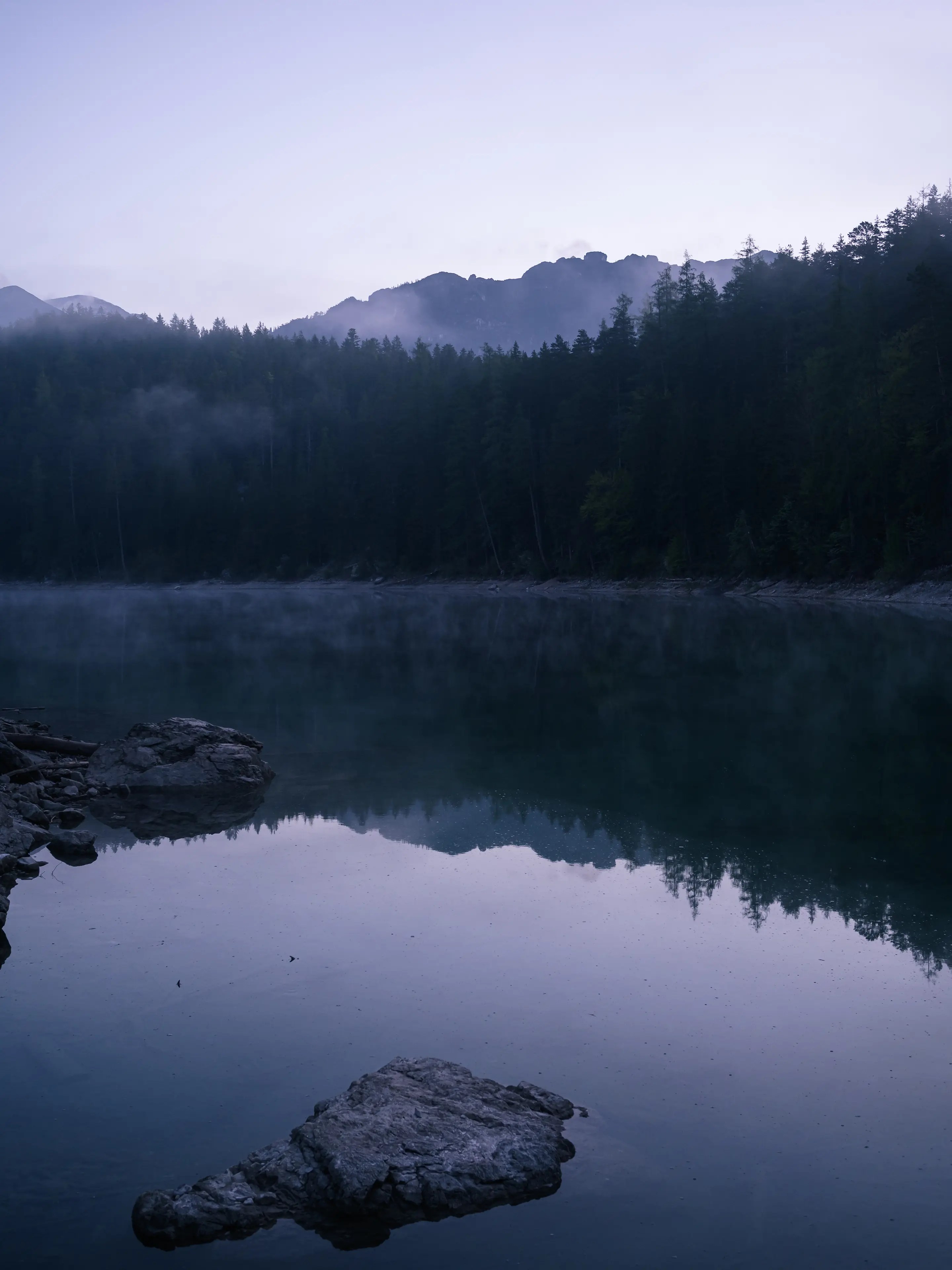 Bäume spiegeln sich im Wasser des Obersees am Eibsee.