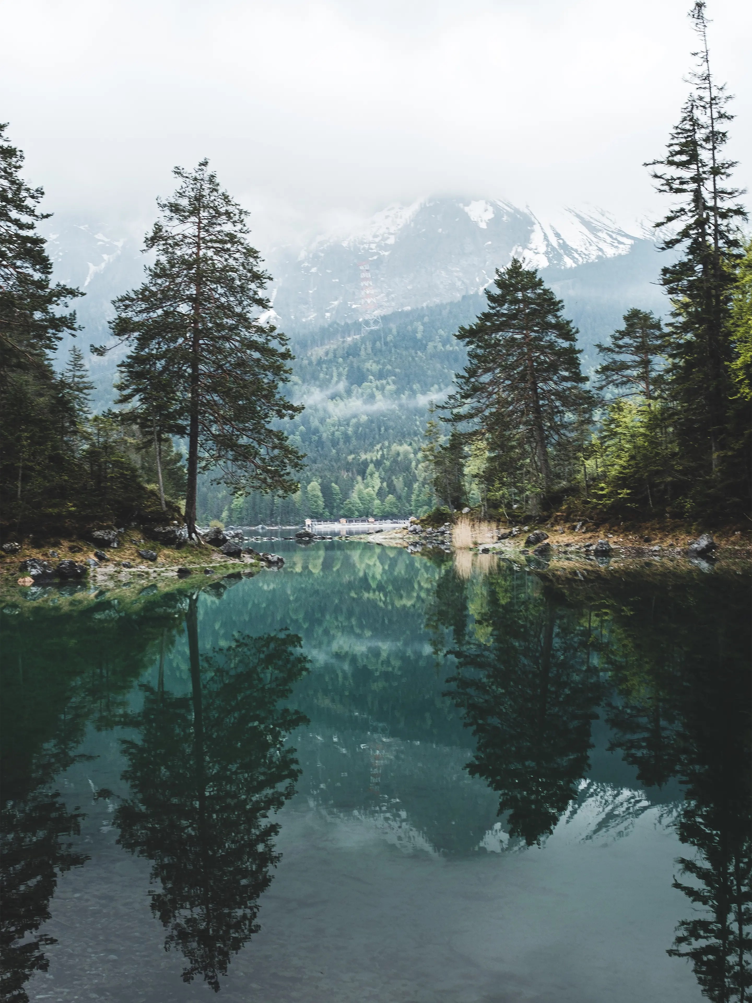 Der Blick am Ende einer weiteren Bucht am Hinkelstein über den See zum von mit Wolken verdeckten Wettersteingebirge