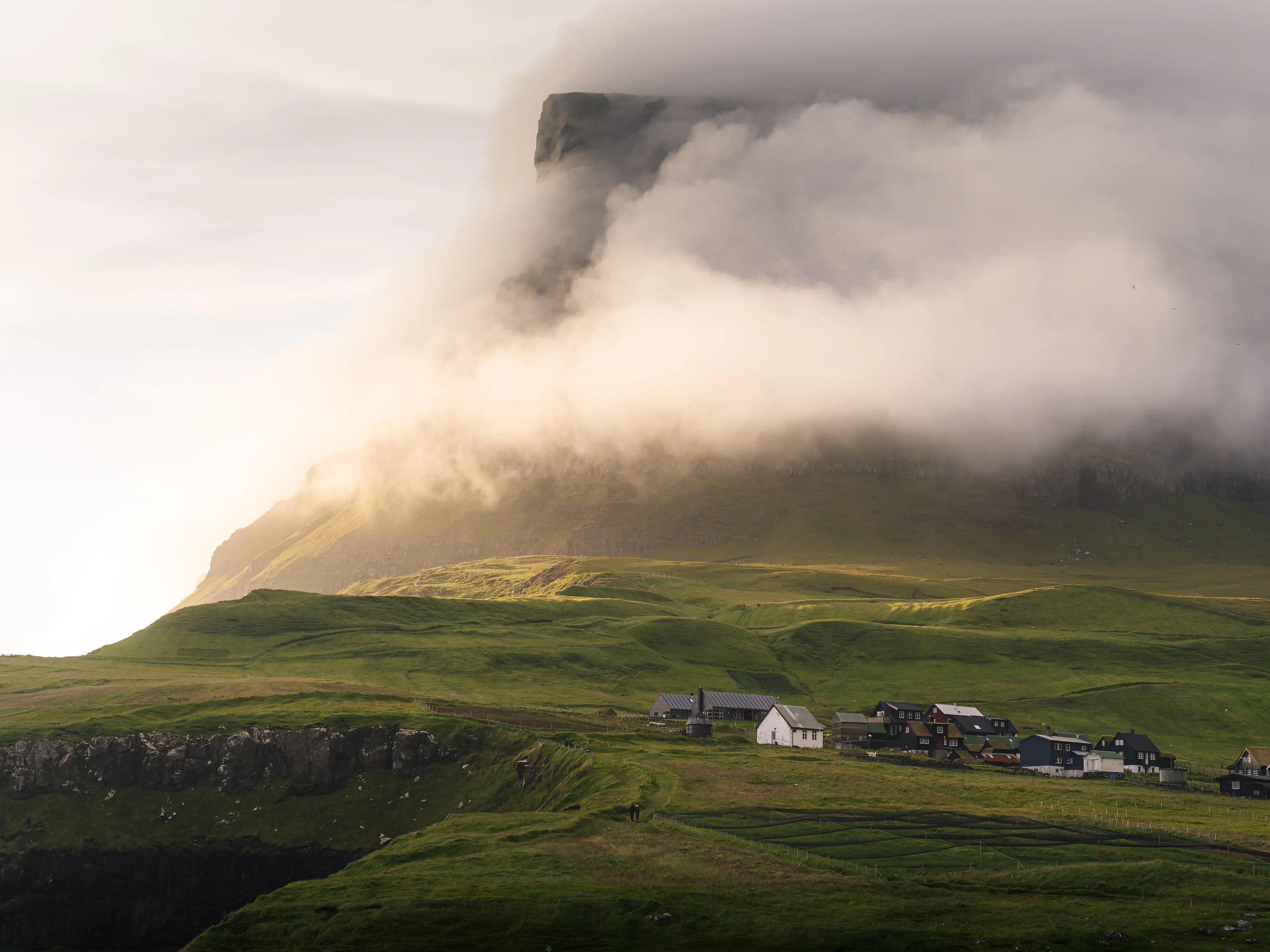 Der Ort Gásadalur auf den Färöer Inseln im Abendlicht