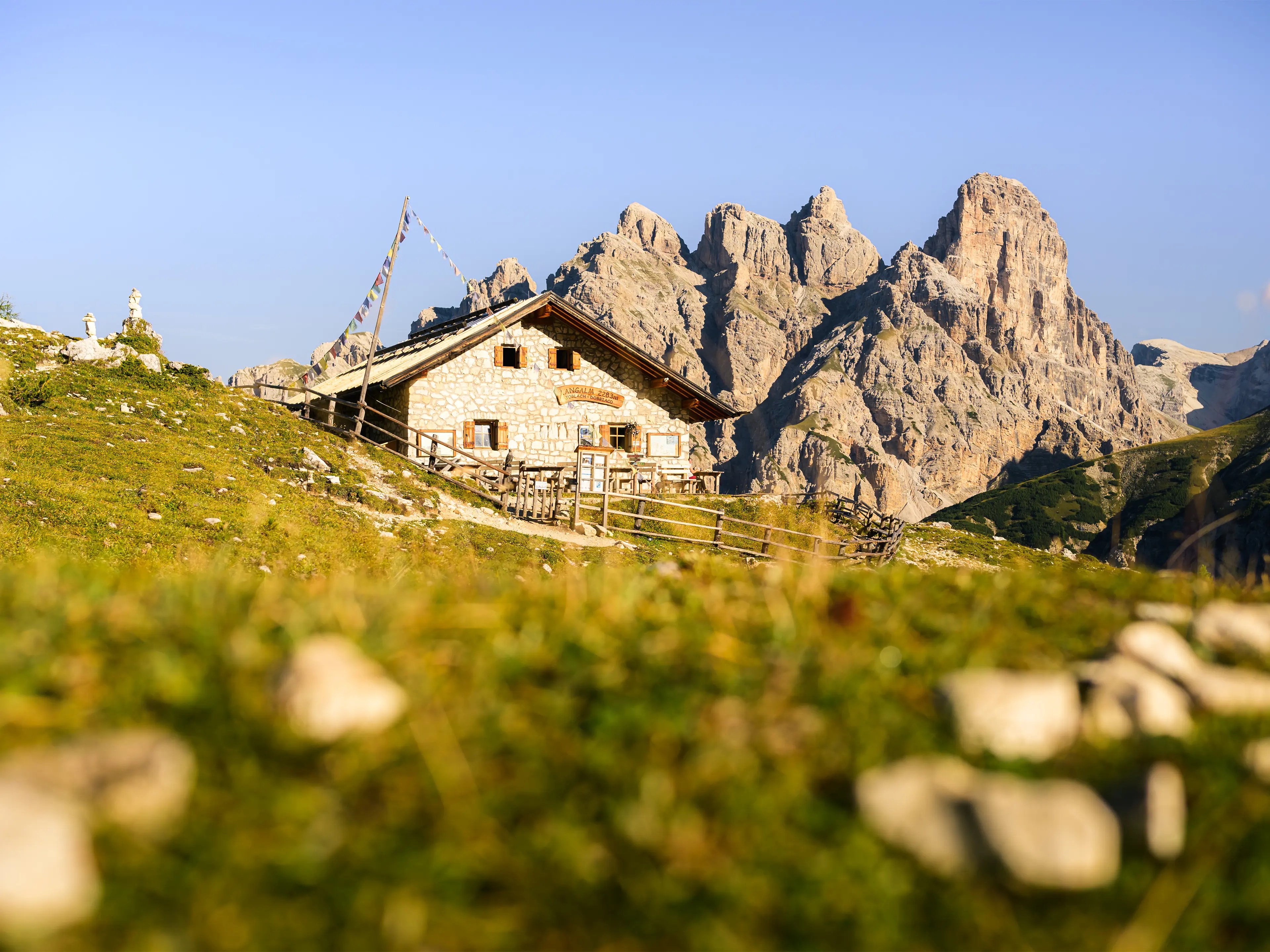 Eine Almhütte mit Berggipfeln im Hintergrund