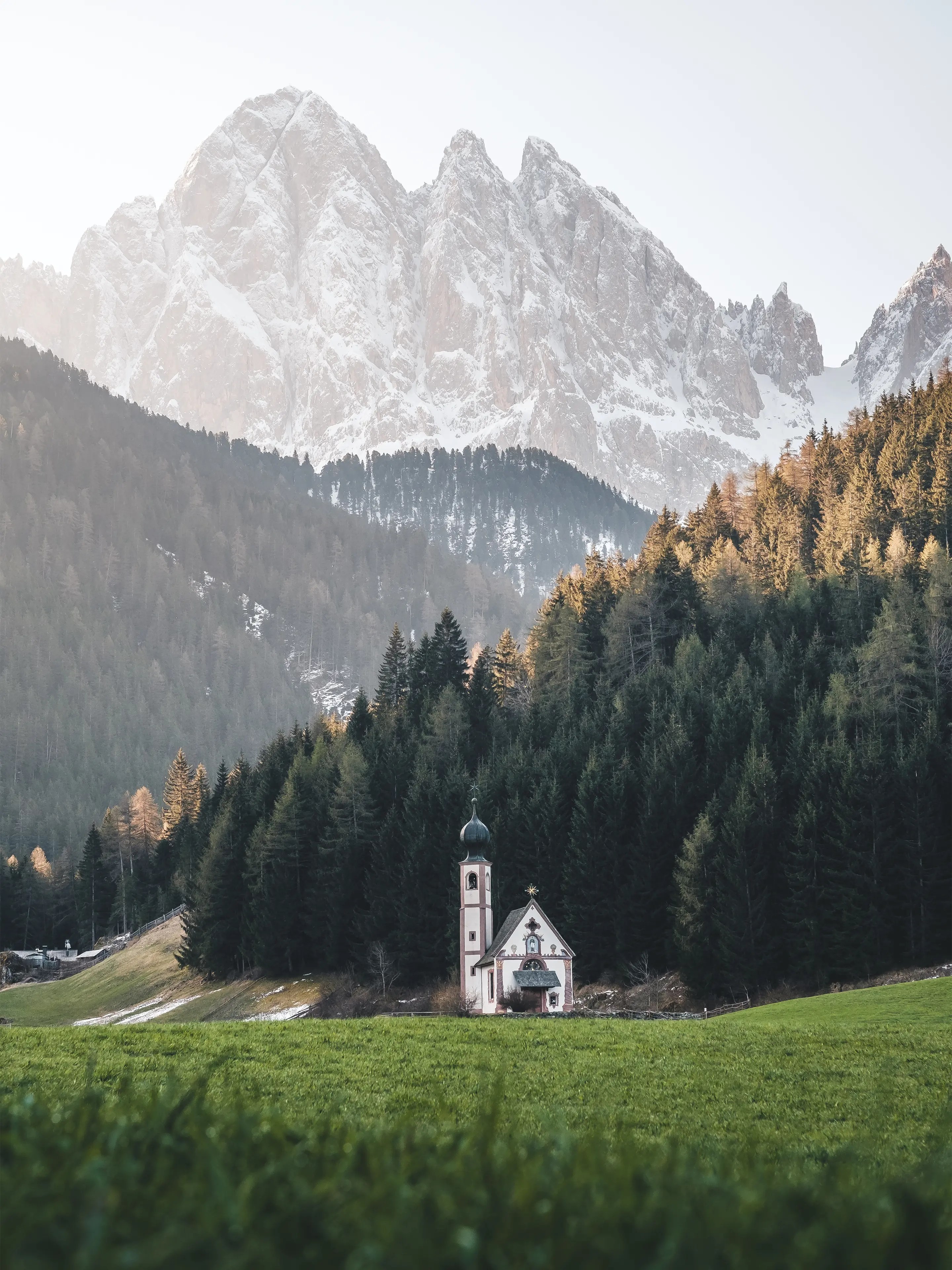 Die Kirche St. Johann in Ranui mit den Geislerspitzen im Hintergrund.