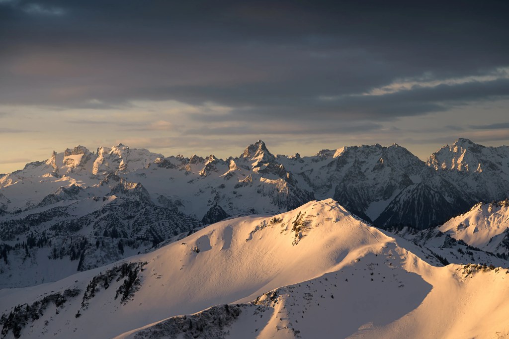 Eine winterliche Berglandschaft mit schneebedeckten Bergen am Morgen.