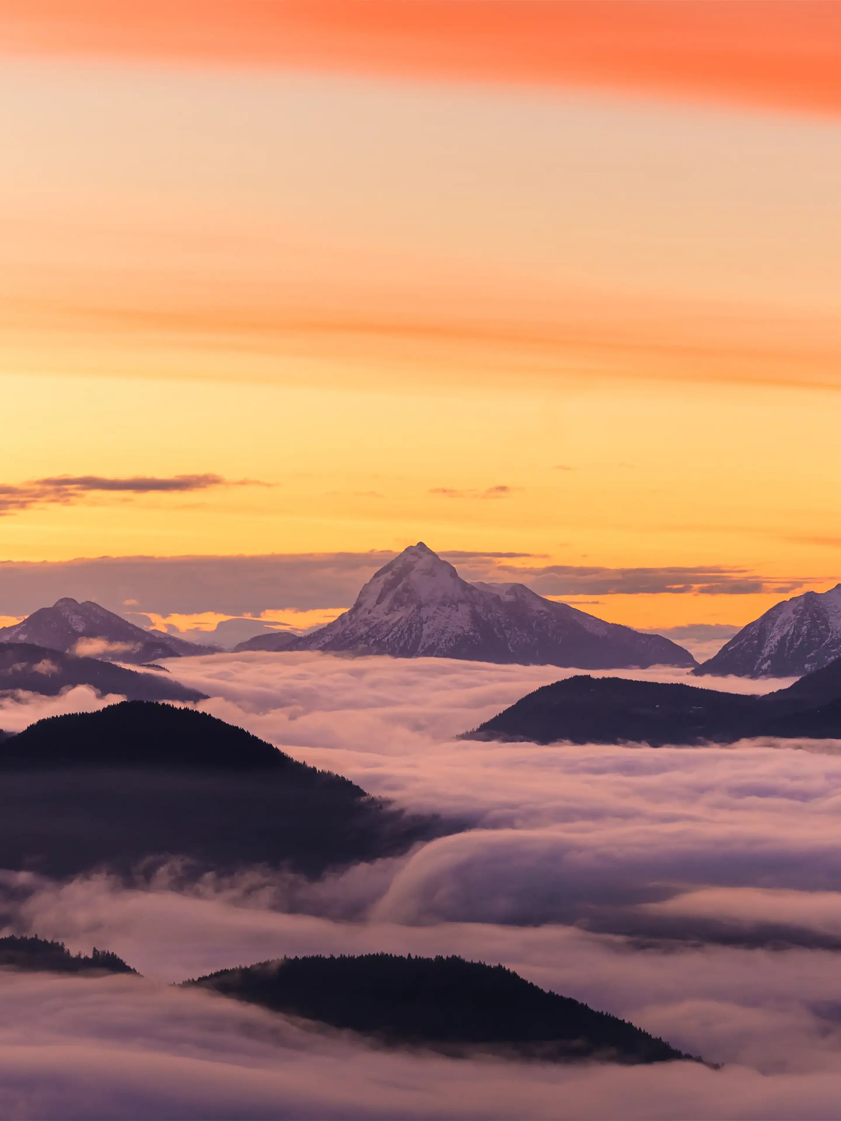 Blick über tief hängenden Nebel und daraus ragenden Bergen zum Guffert im Morgnelicht.