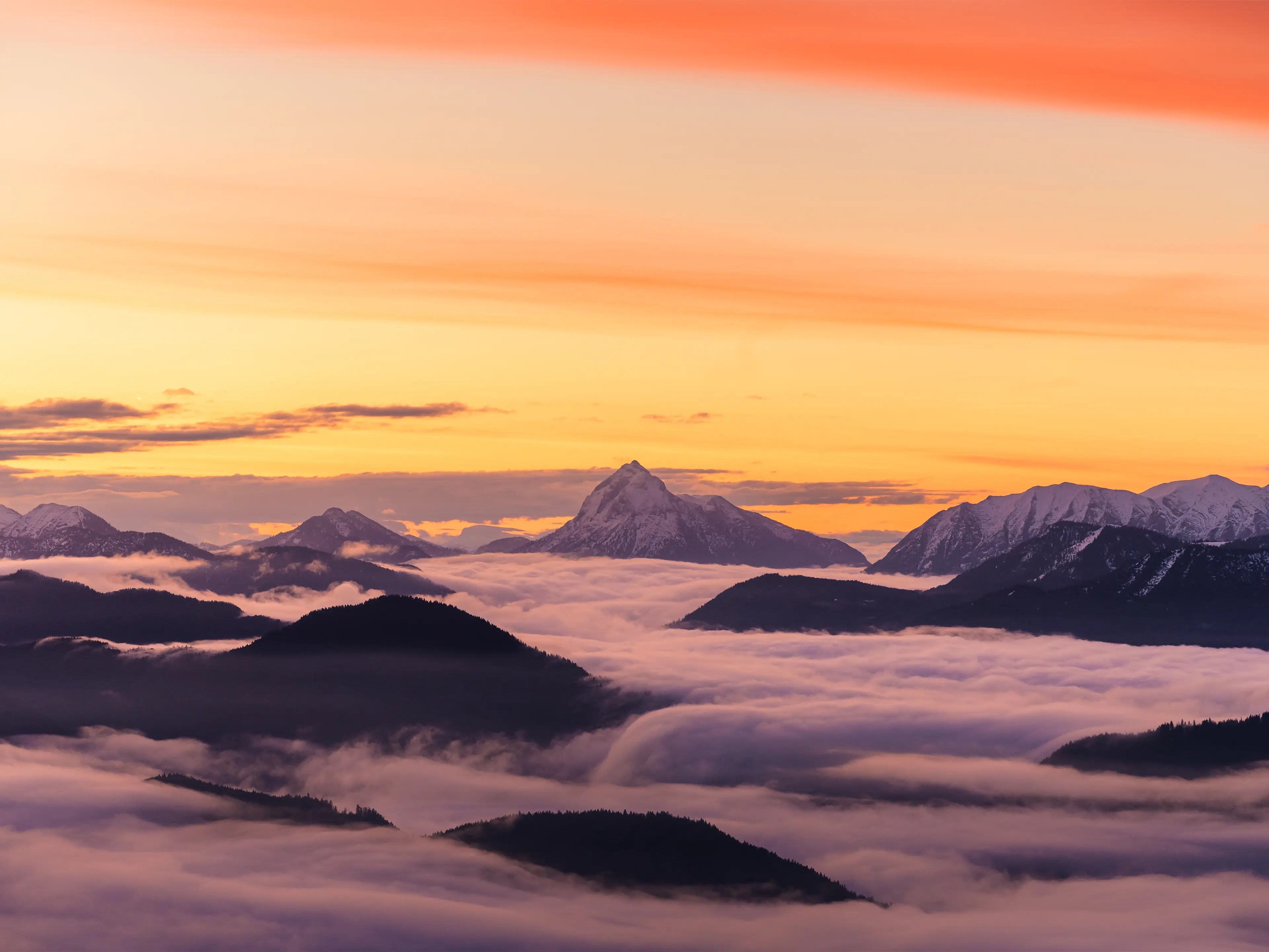 Blick über tief hängenden Nebel und daraus ragenden Bergen zum Guffert im Morgnelicht.