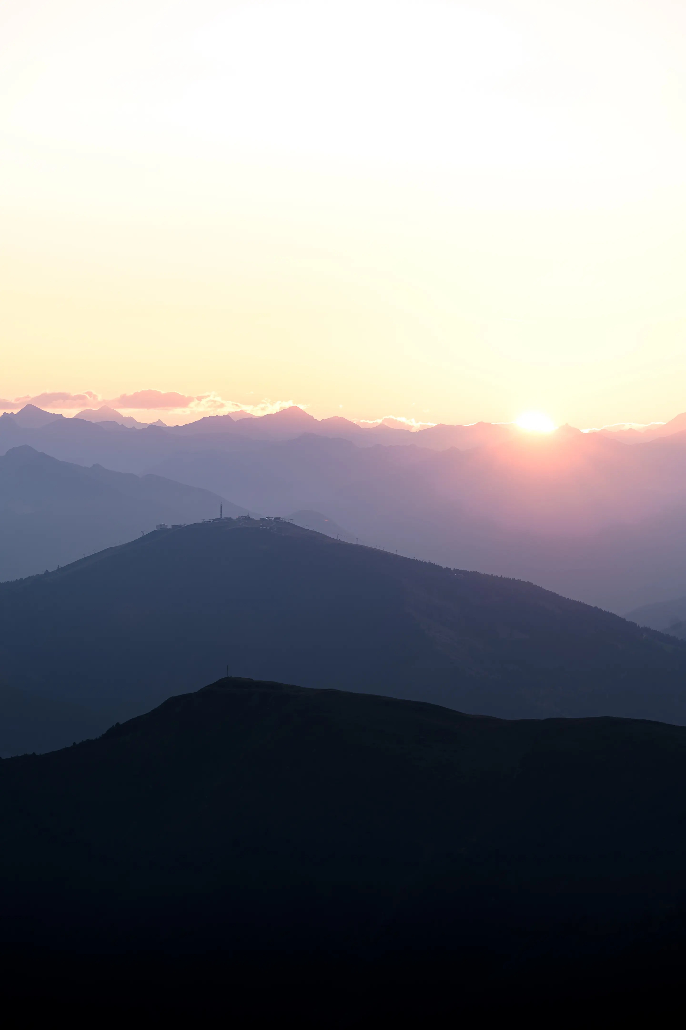 Umrisse von Bergen im Morgenlicht mit Blick zur aufgehenden Sonne.