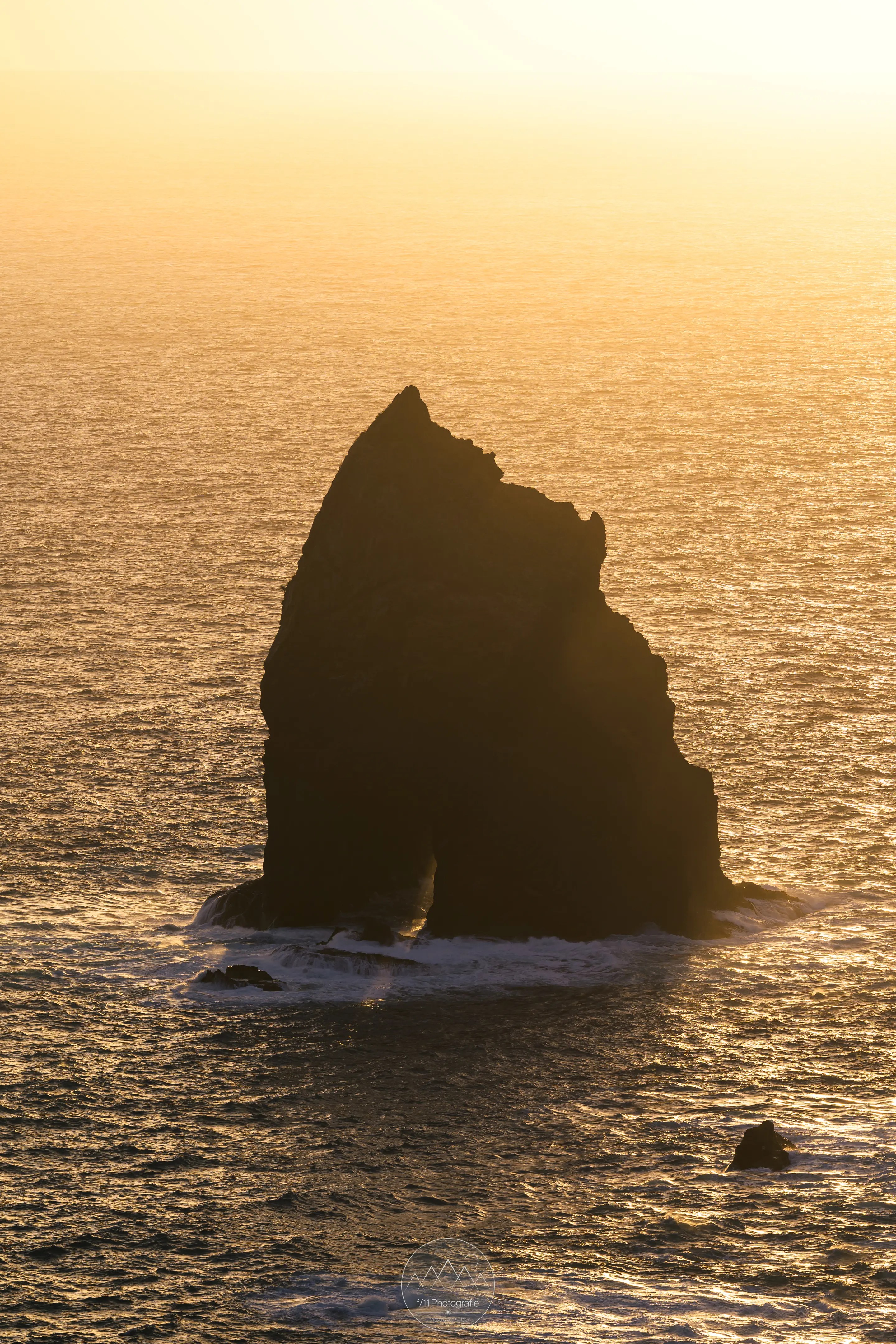 Ein großer Felsen im Licht der goldenen Stunde vor der Küste Madeiras.