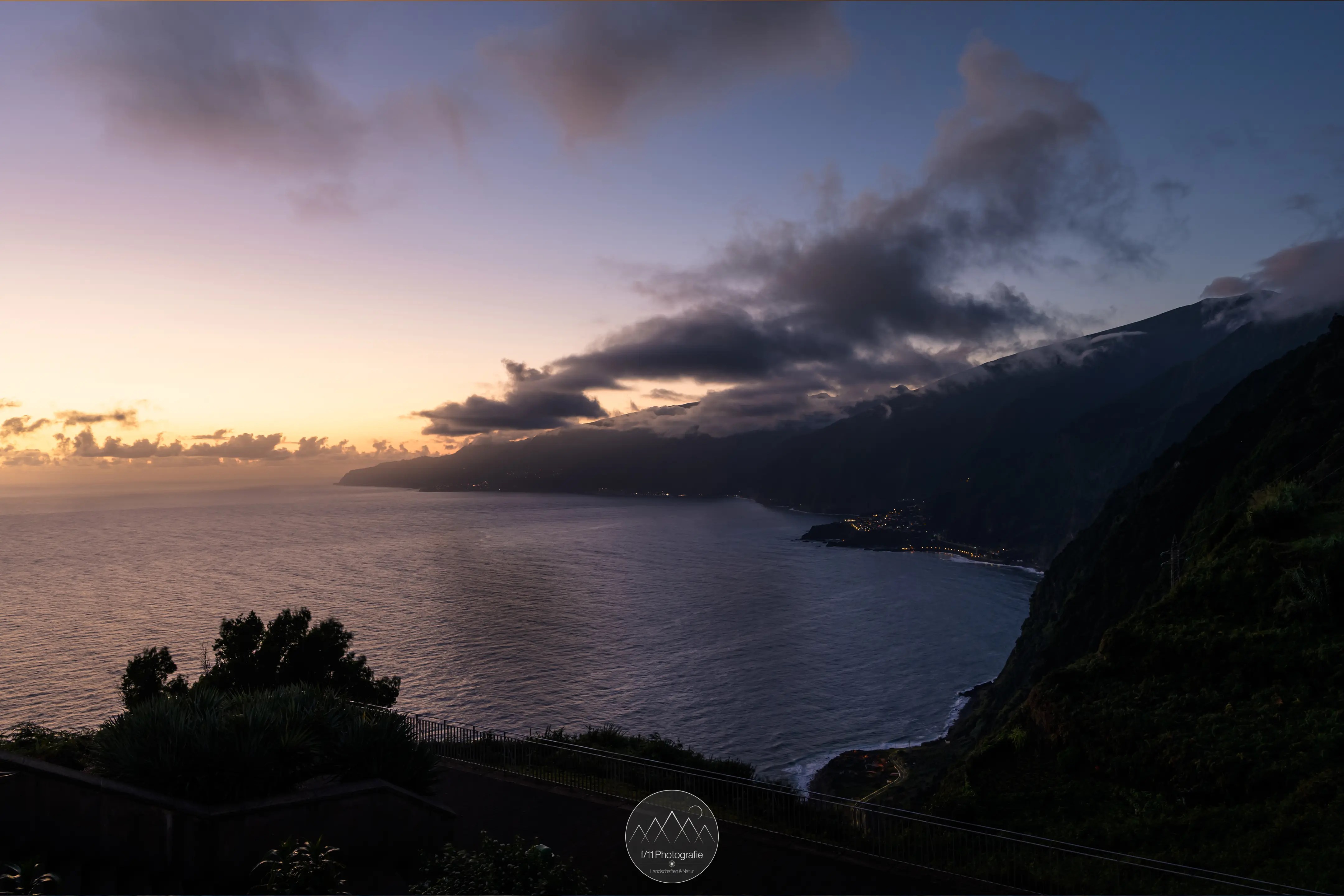 Blaue Stunde vor Sonnenaufgang auf Madeira mit Blick auf die Küste und Ozean.