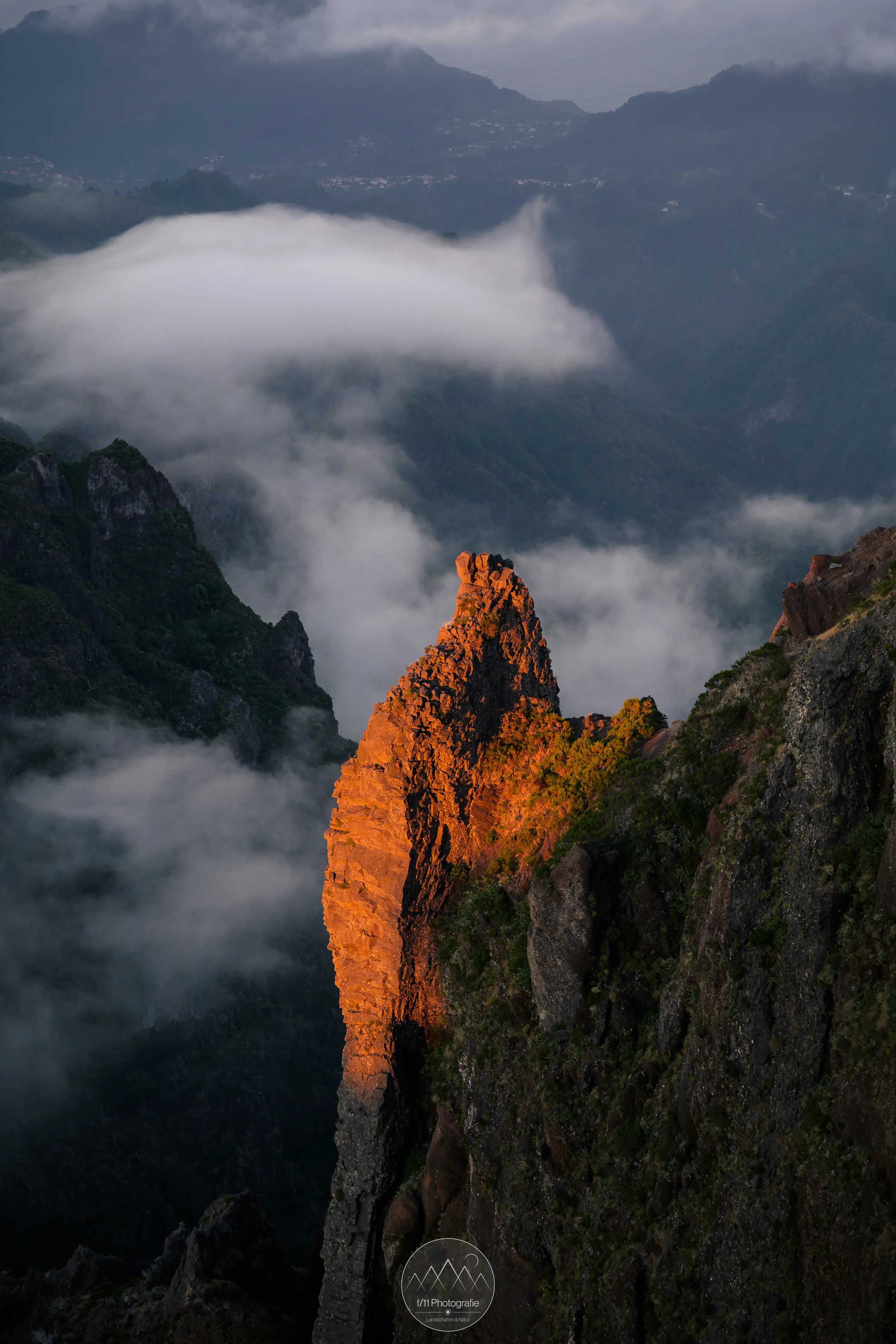 Ein Felsvorsprung leuchtet Orange im Abendlicht.