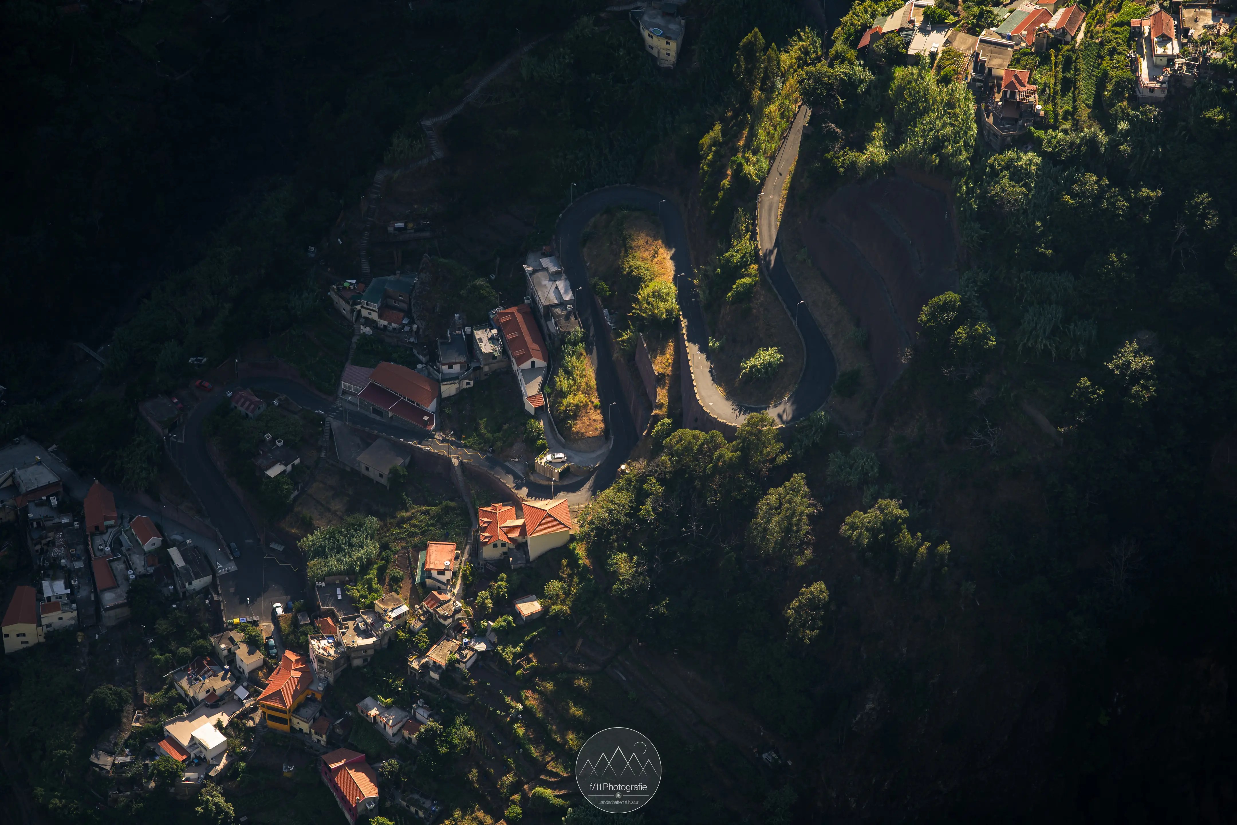 Eine Straße schlängelt sich in Serpentinen das steile Tal entlang.