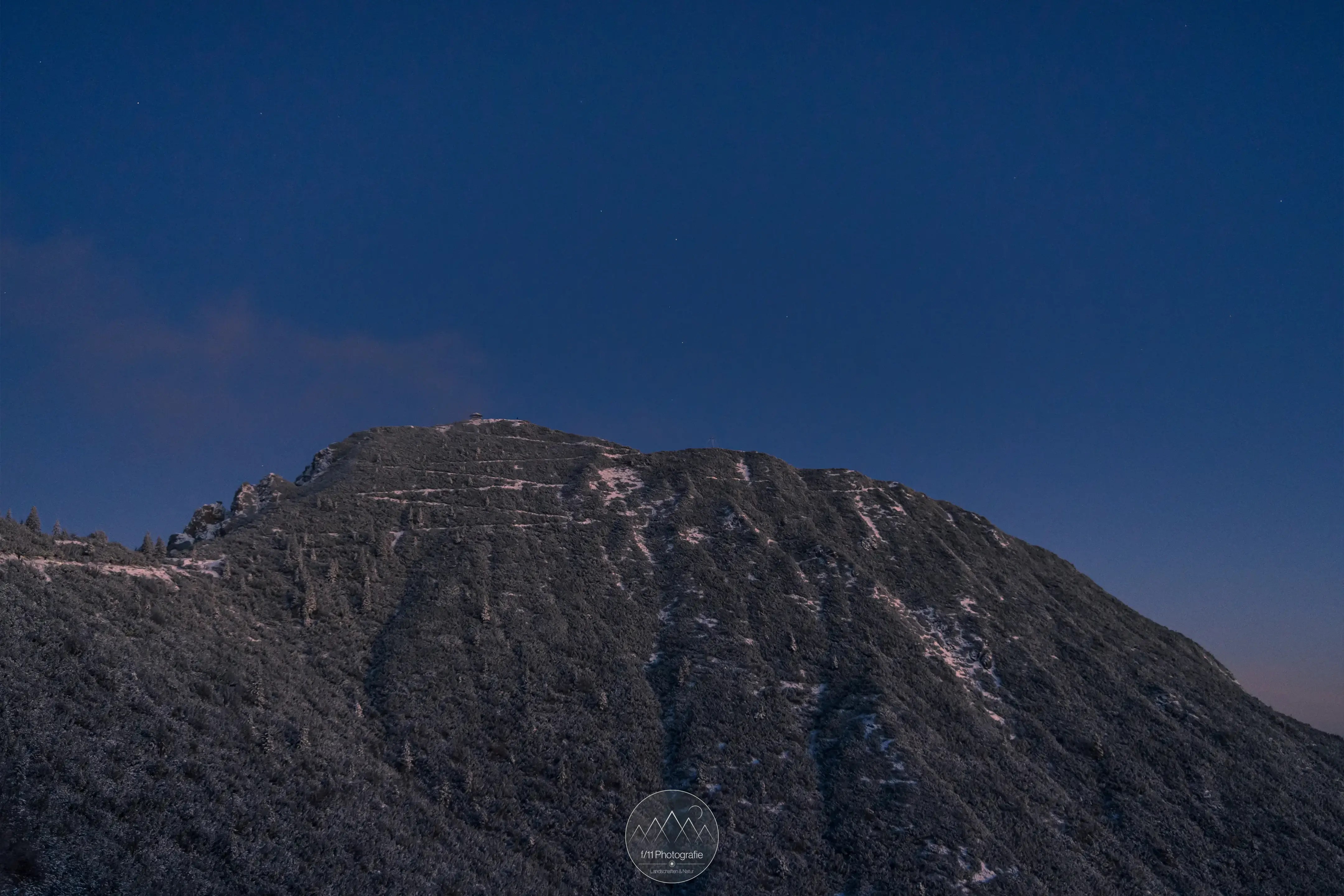 Der Blick auf den verschneiten Gipfel des Herzogstands knapp unterhalb des Herzogstandhauses.
