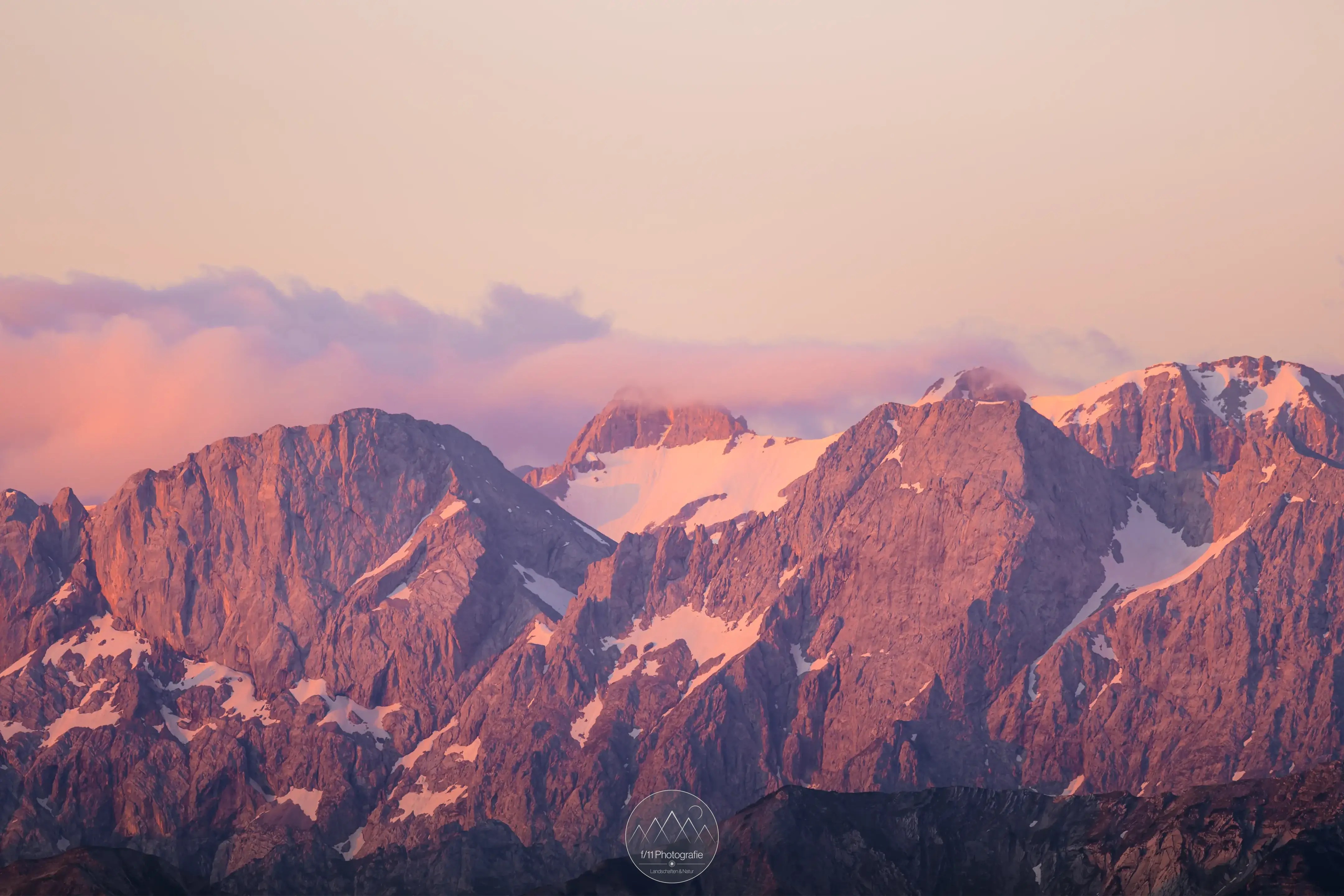 Mit einem Teleobjektiv lassen auch weiter entfernte Gipfel und Motive sehr gut einfangen. Hier die zum Sonnenaufgang leuchtenden Gipfel im Karwendelgebirge.