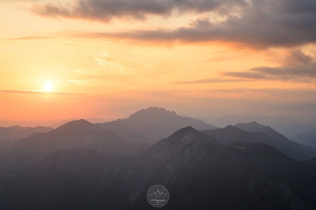 Sommerlicher Sonnenaufgang am Herzogstand. Durch den Dunst ist das Licht leicht diffus und taucht die Berge in sehr weiches Licht.