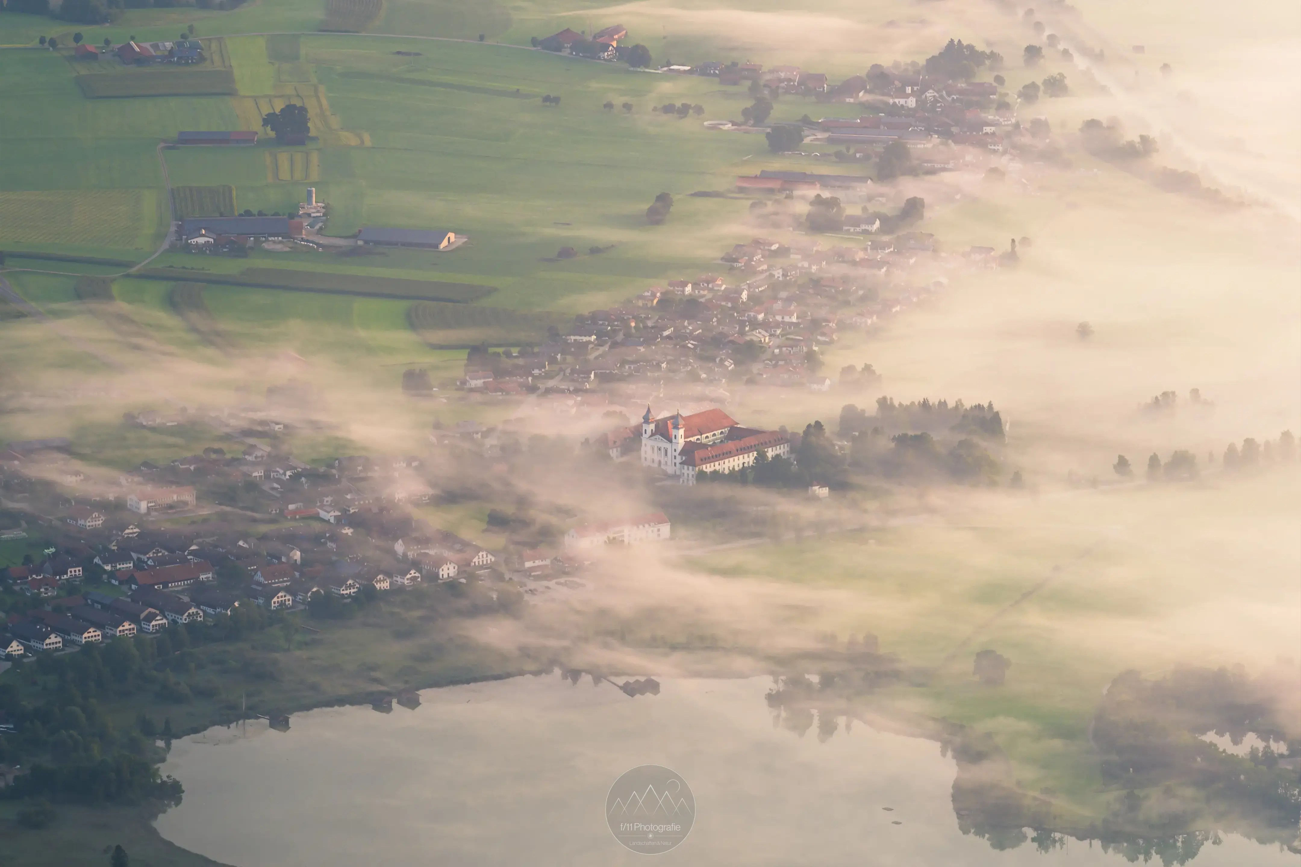 Blick auf Schlehdorf am Kochelsee vom Herzogstand im Morgennebel