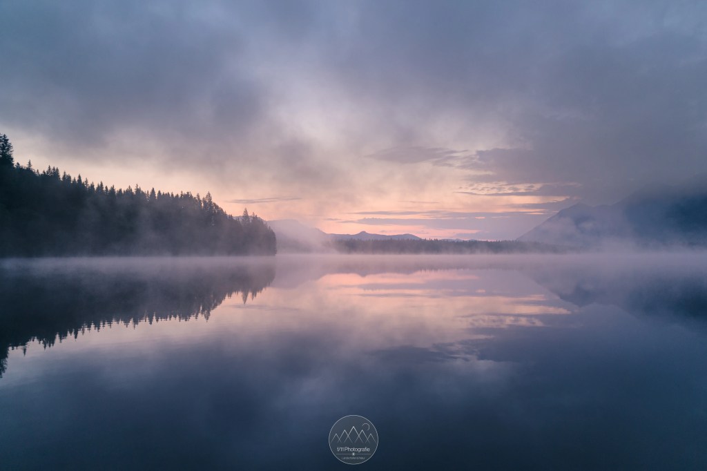 Die Blaue Stunde am Barmsee an einem Frühlingsmorgen. Sanfte Blau- und Orangetöne erhellen die Himmel.