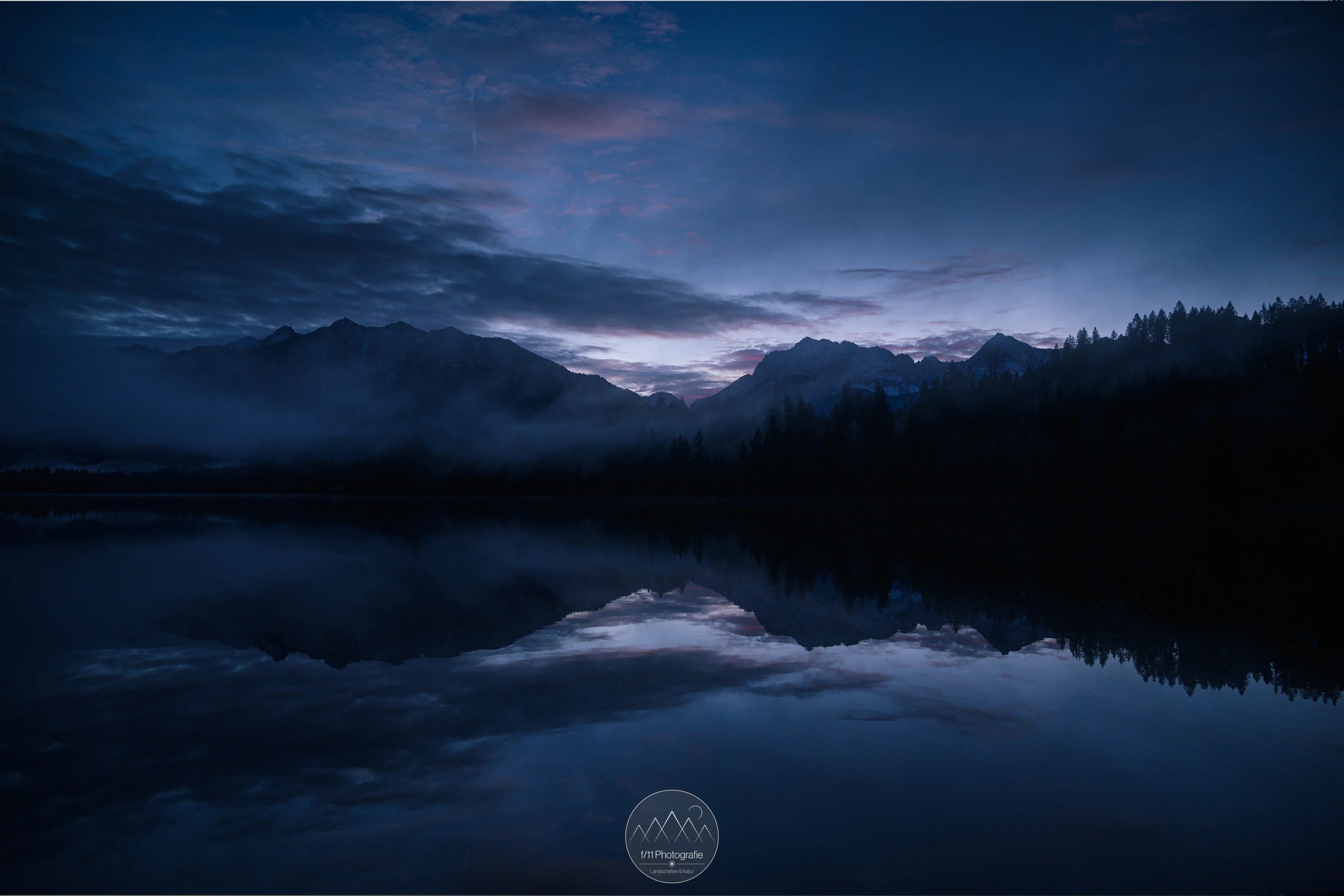 Blaue Stunde am Barmsee an einen Dezembermorgen. Die Wolken beginnen langsam zu leuchten.