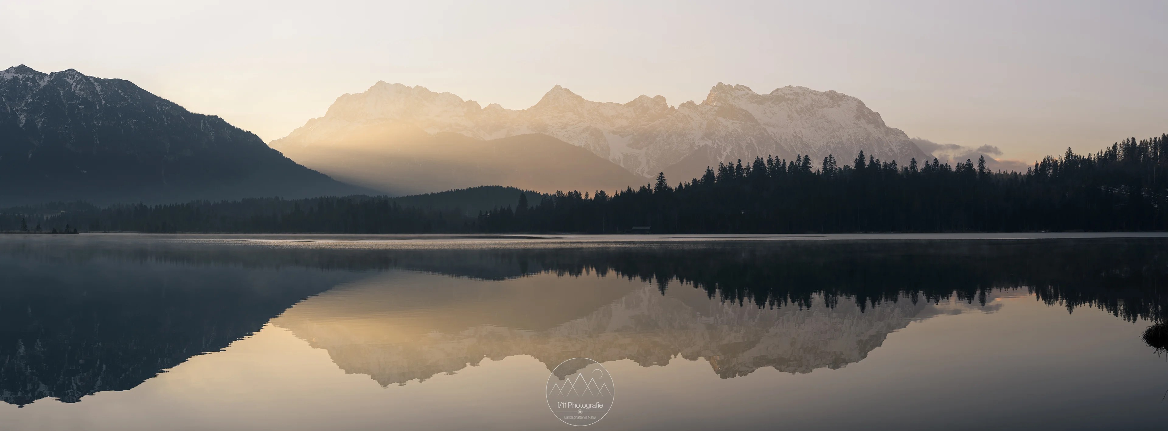 Das Karwendelgebirge leuchtet im sanften Streiflicht der aufgehenden Sonne.