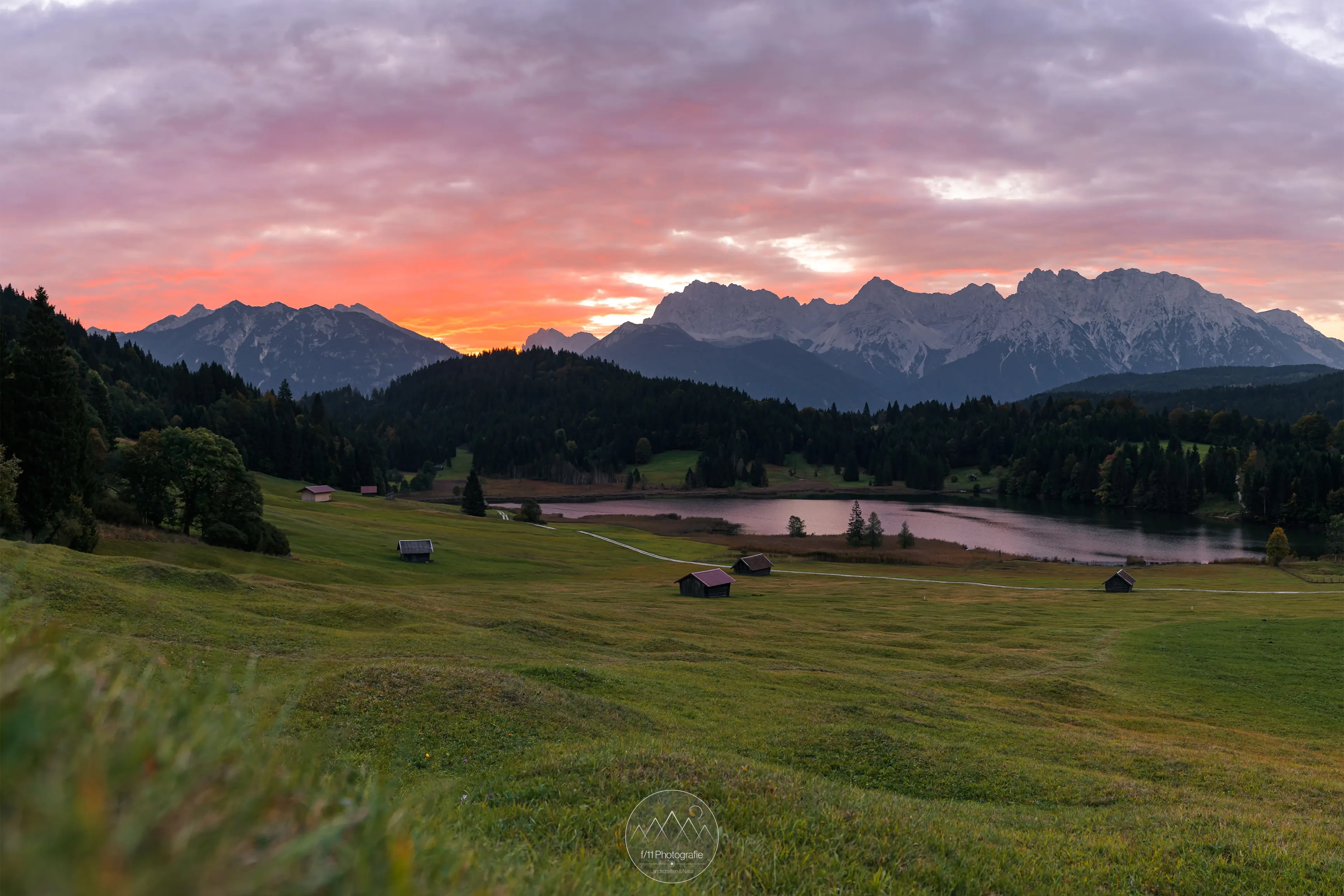 Die Sonne geht im Herbst zwischen dem Karwendelgebirge und der Soierngruppe auf. Bei einer hohen Wolkendecke ergeben sich bereits vor Sonnenaufgang tolle Farben.