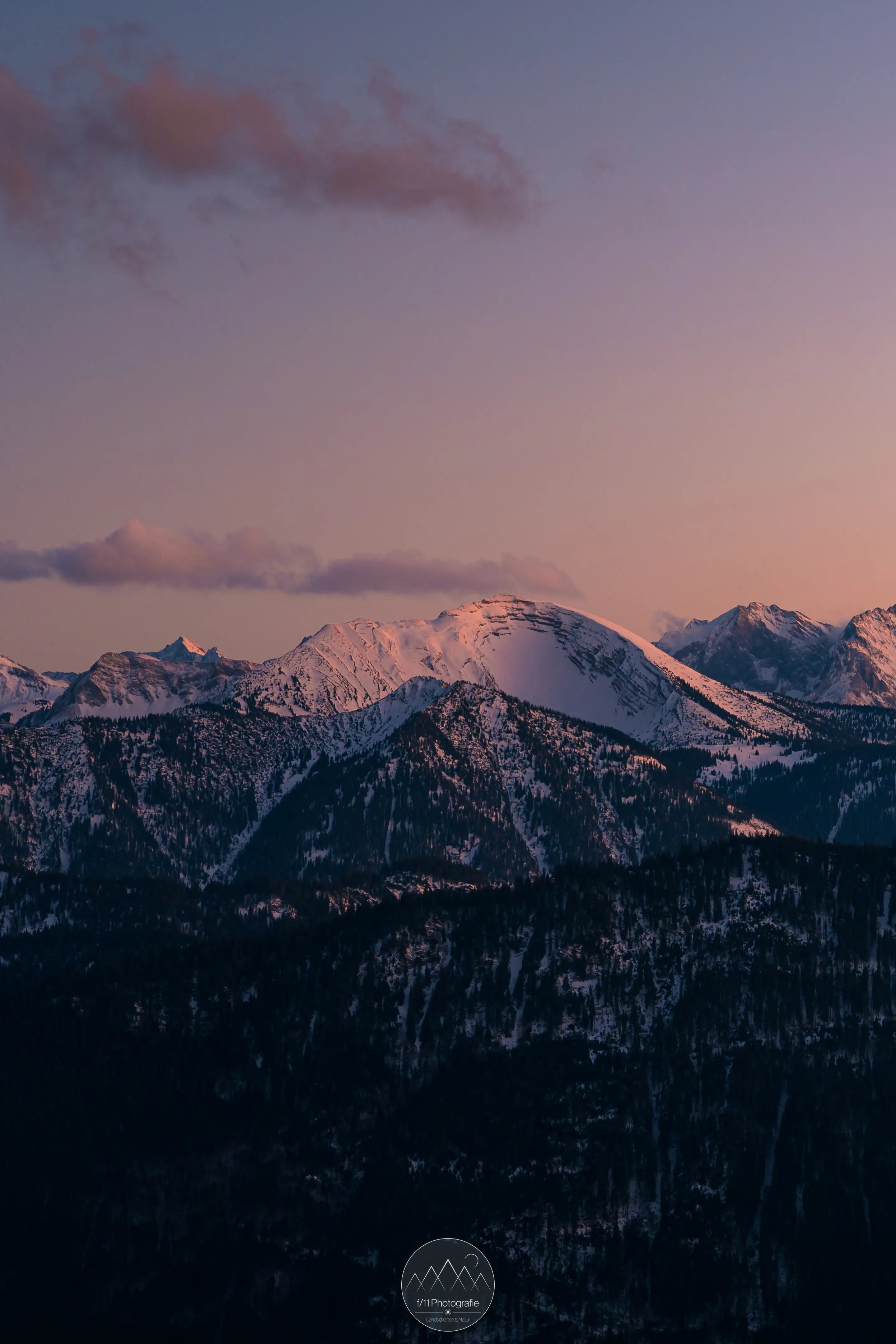Das Karwendelgebirge leuchtet sanft im indirekten Sonnenlicht der Blauen Stunde.