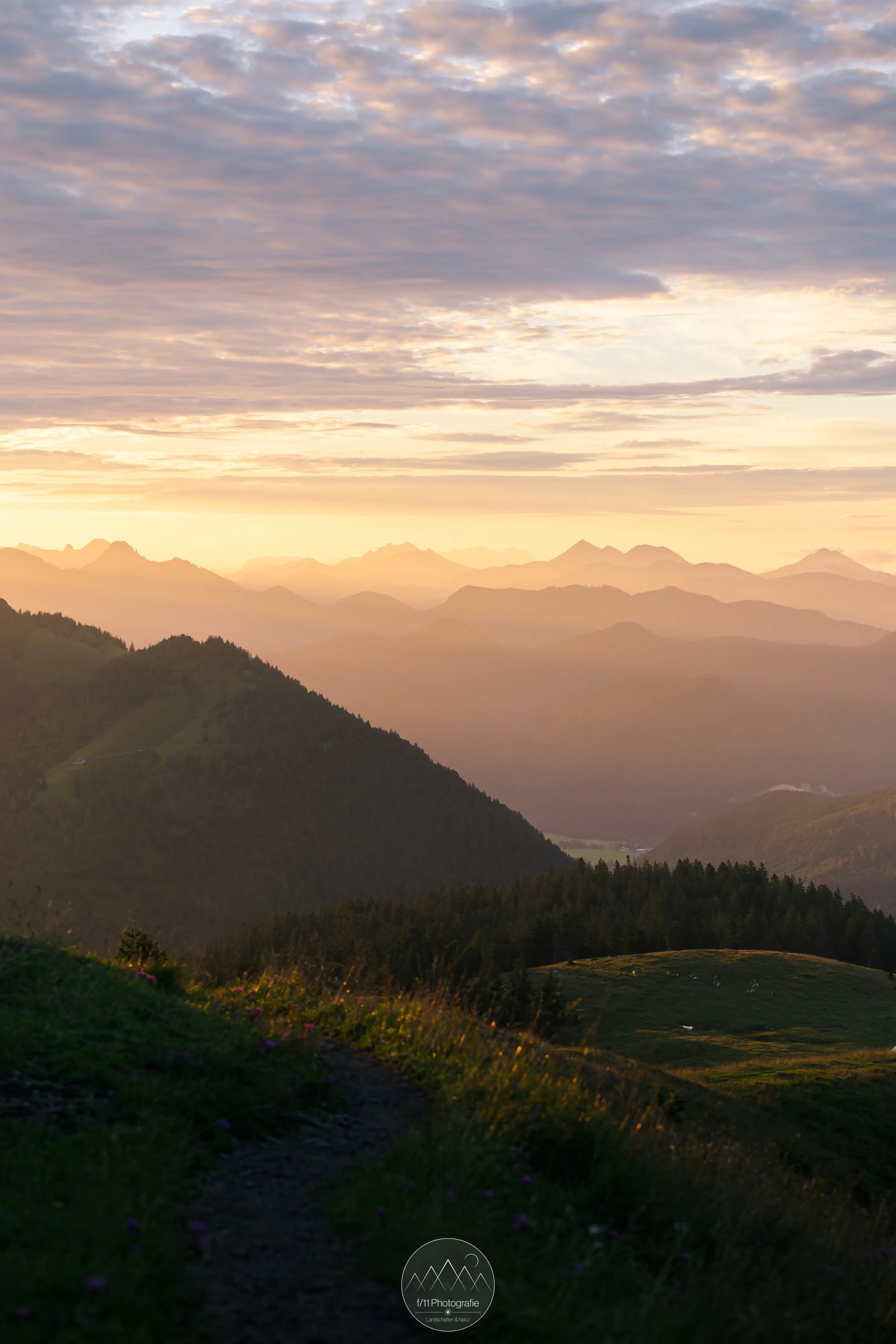 Der Blick in die orange leuchtenden bayerischen Voralpen zur goldenen Stunde.