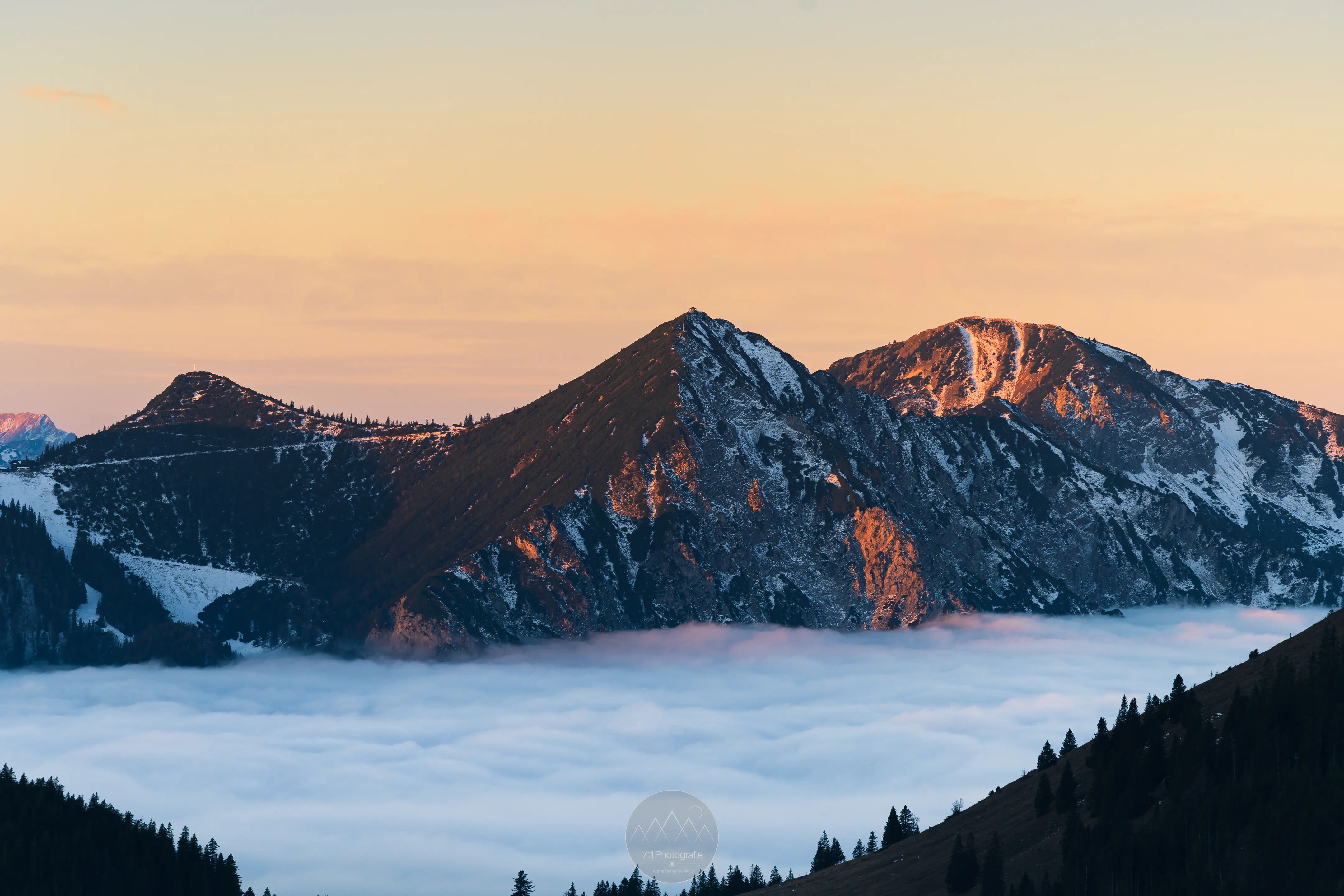 Der Blick zum Herzogstand mit einer leichten Schneedecke zum Sonnenaufgang.