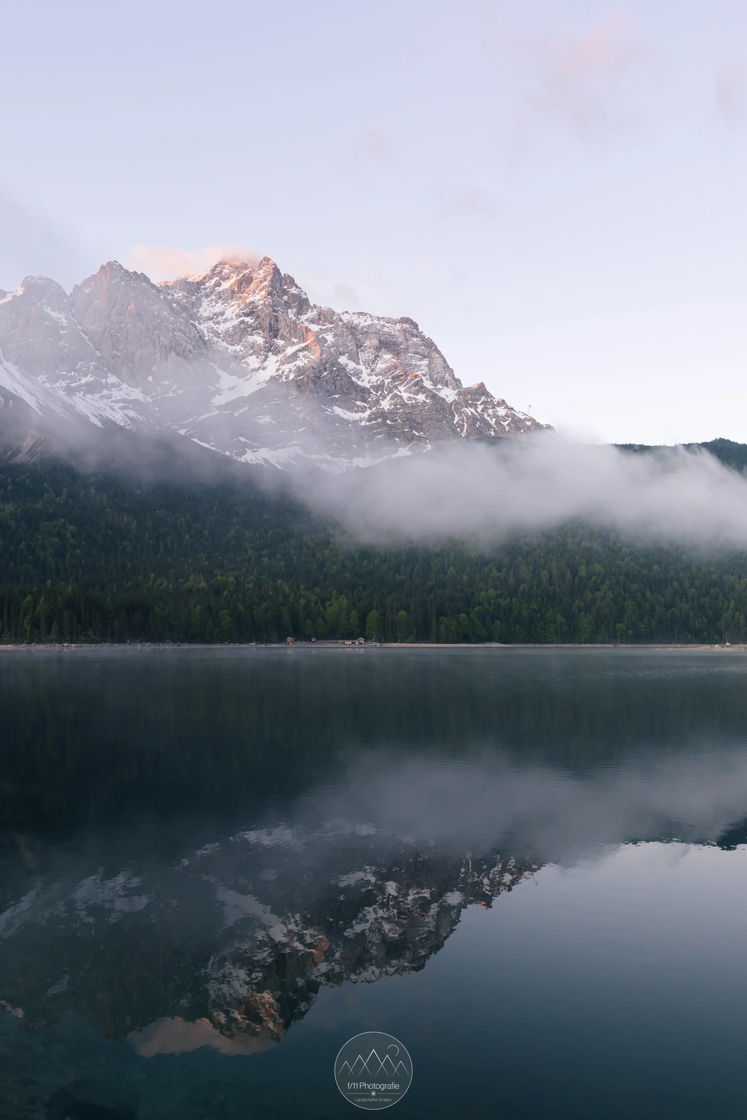 Der Eibsee am Morgen. Hier war eine Panoramaaufnahme nötig, um genug Himmel auf das Bild zu bekommen.