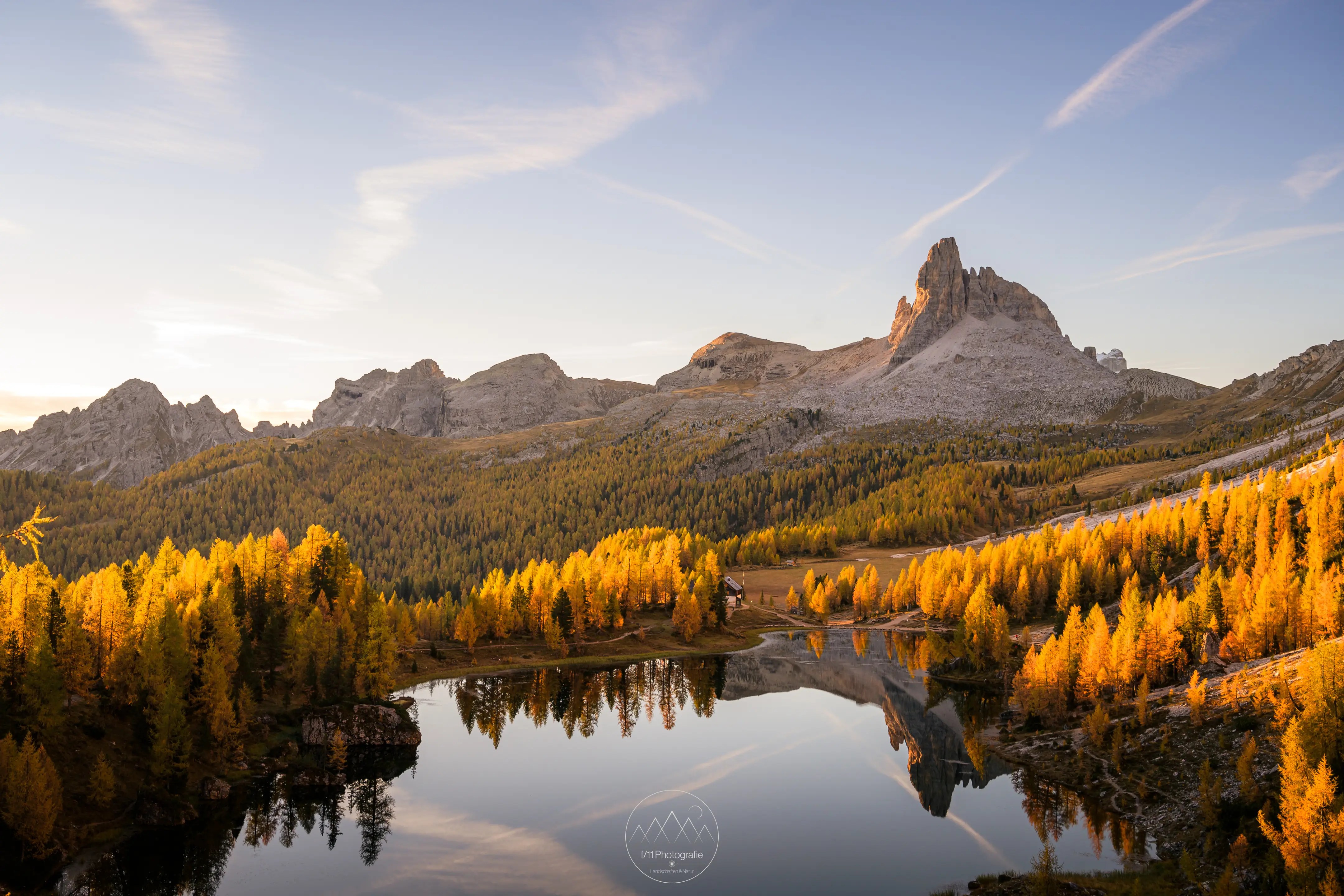 Sonnenaufgang im Herbst am Lago Federa mit seinen gold gelben Lärchenwäldern.