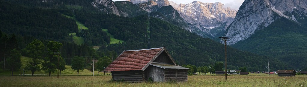 Eine Almhütte eingebettet in eine Berglandschaft