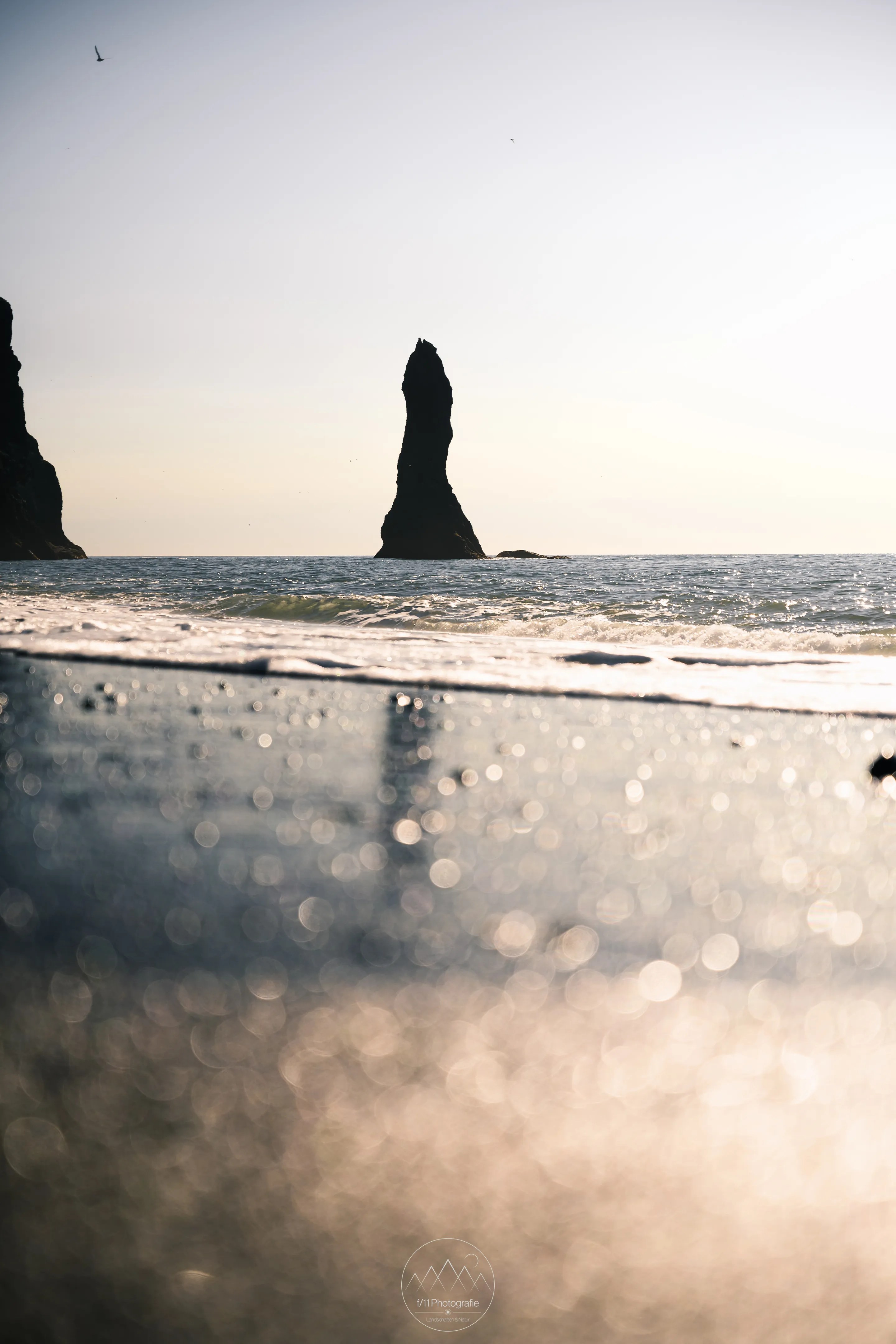 Die Reynisdrangar geannte Felsnadel am Strand von Reynisfjara.