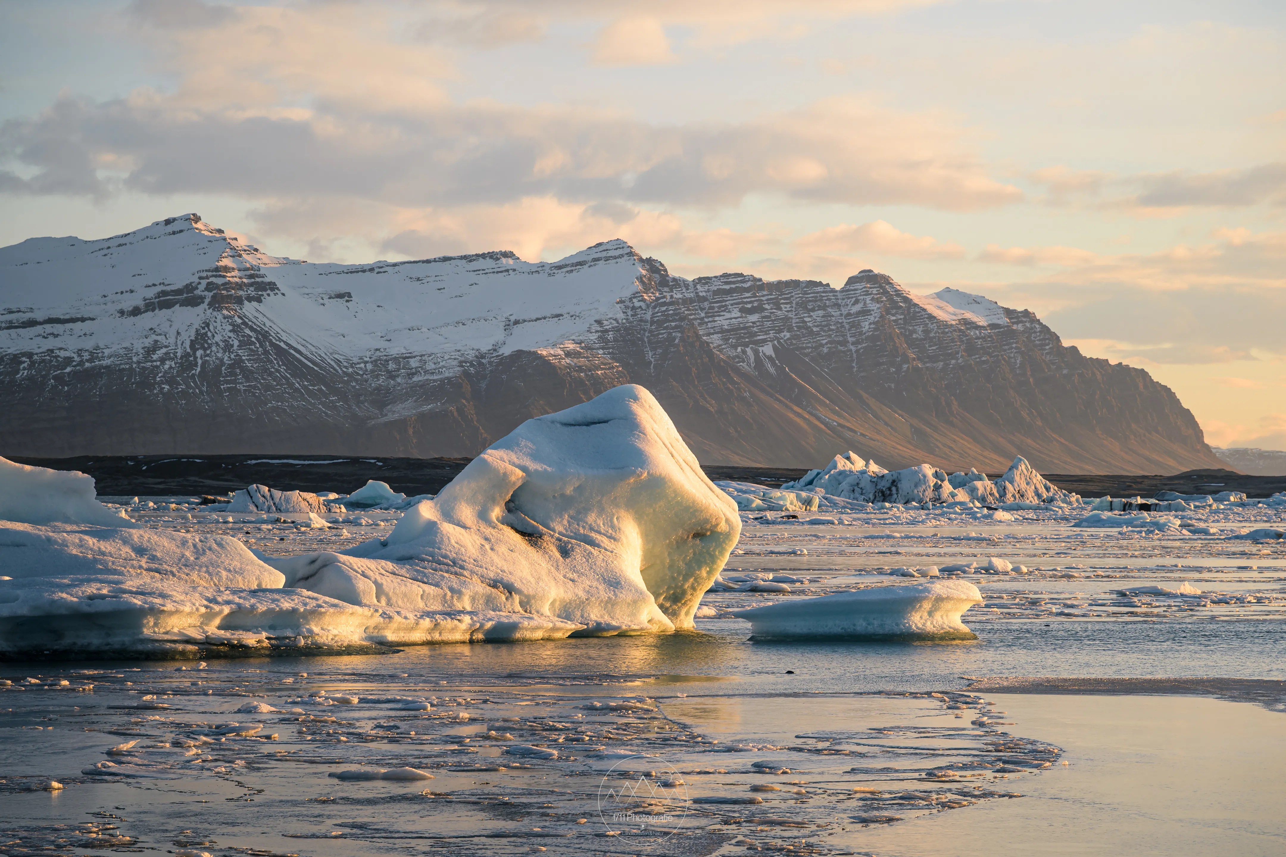 Die Gletscherlagune Jökulsárlón im sanften Morgenlicht. Die Eisberge in der Lagune werden durch die Eisdecke festgehalten