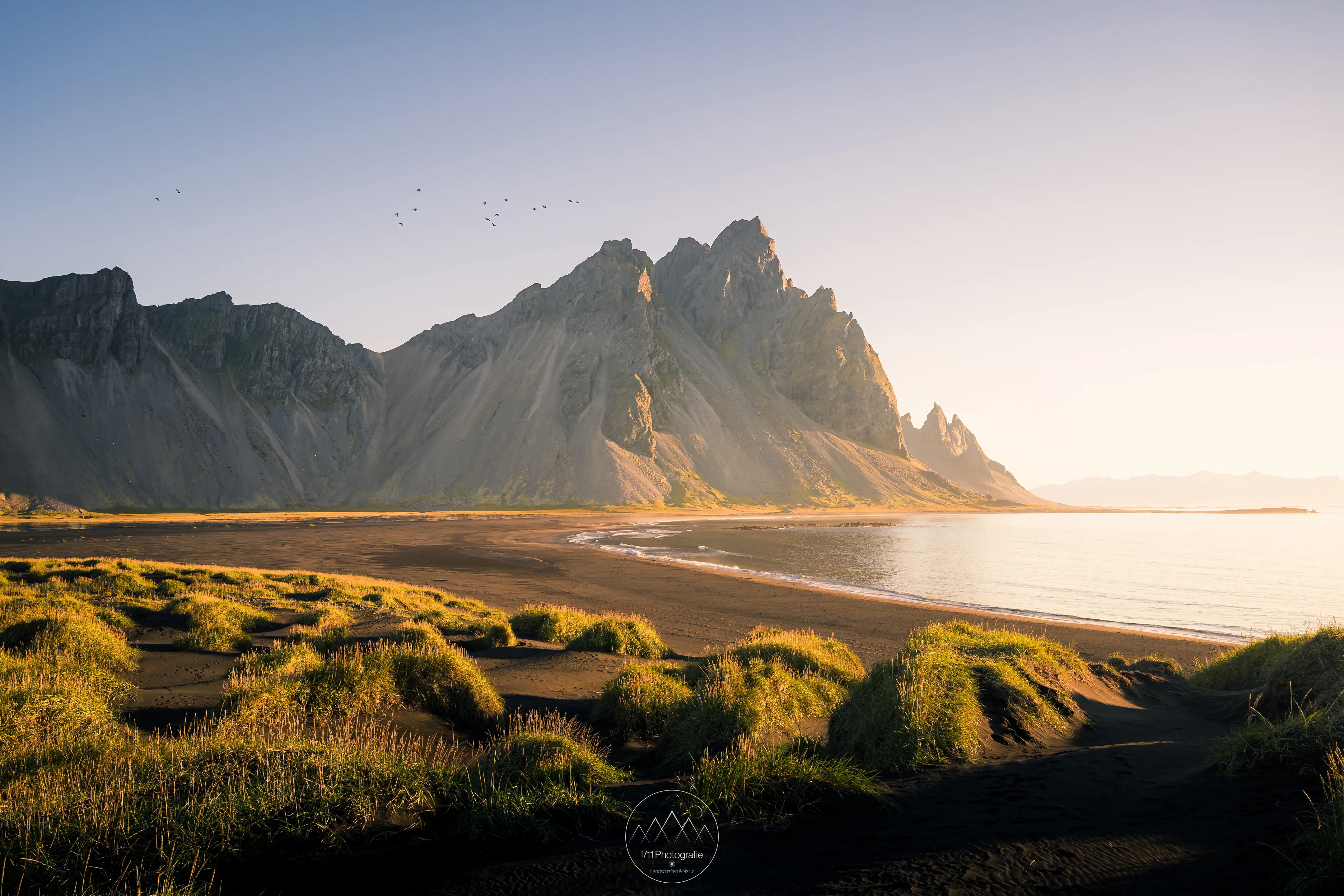 Der Gipfel des Vestahorn leuchtet im Morgenlicht über dem Strand von Stokksnes.